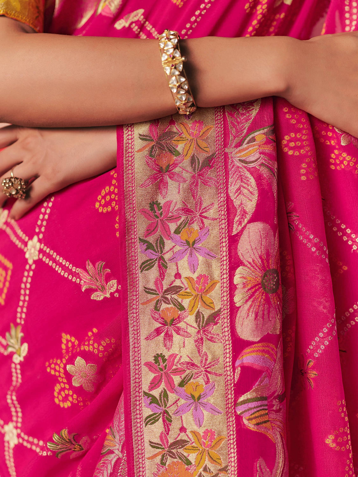 Vibrant pink floral saree with gold border, traditional Indian ethnic wear, perfect for festive occasions.