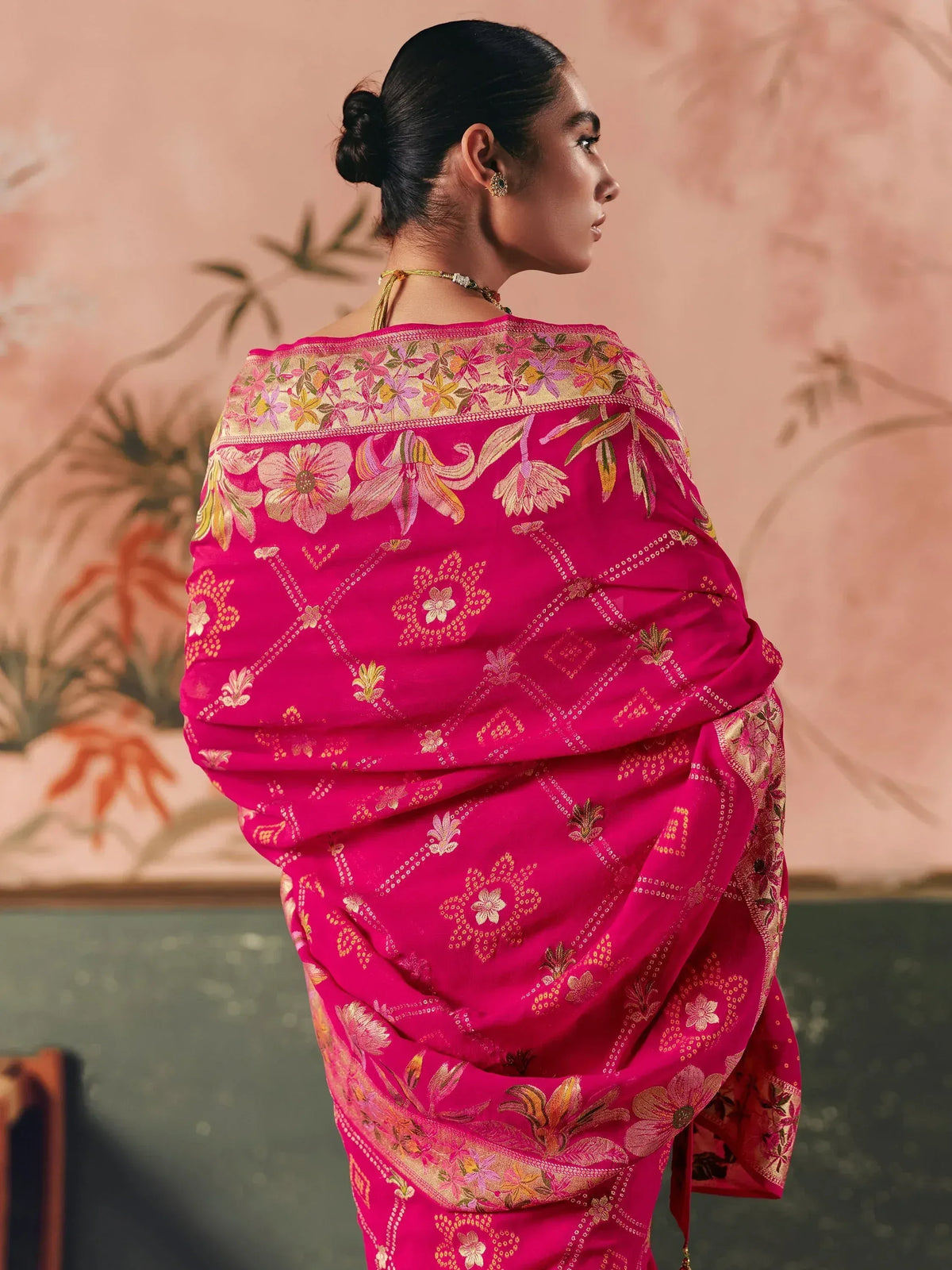 Vibrant pink floral embroidered saree with golden detailing, perfect for ethnic occasions