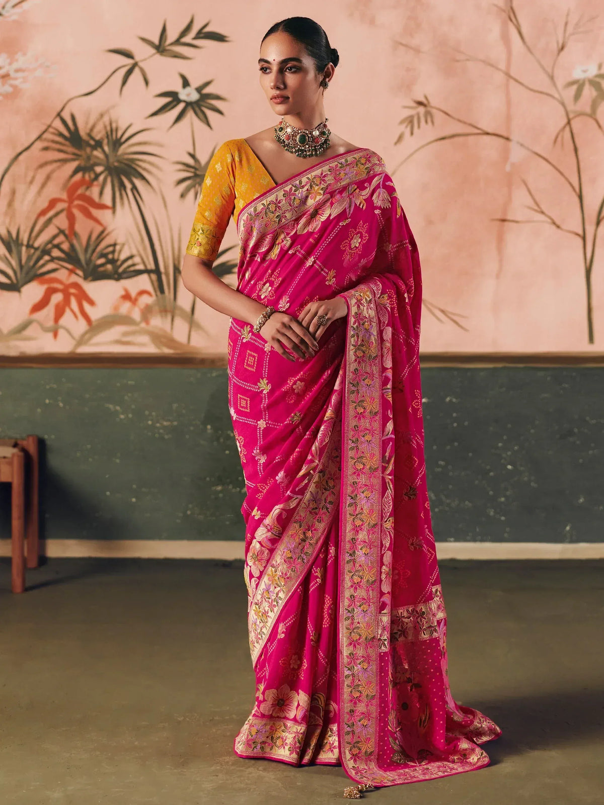 Pink floral embroidered saree with golden border, paired with yellow blouse, perfect for Indian ethnic occasions.
