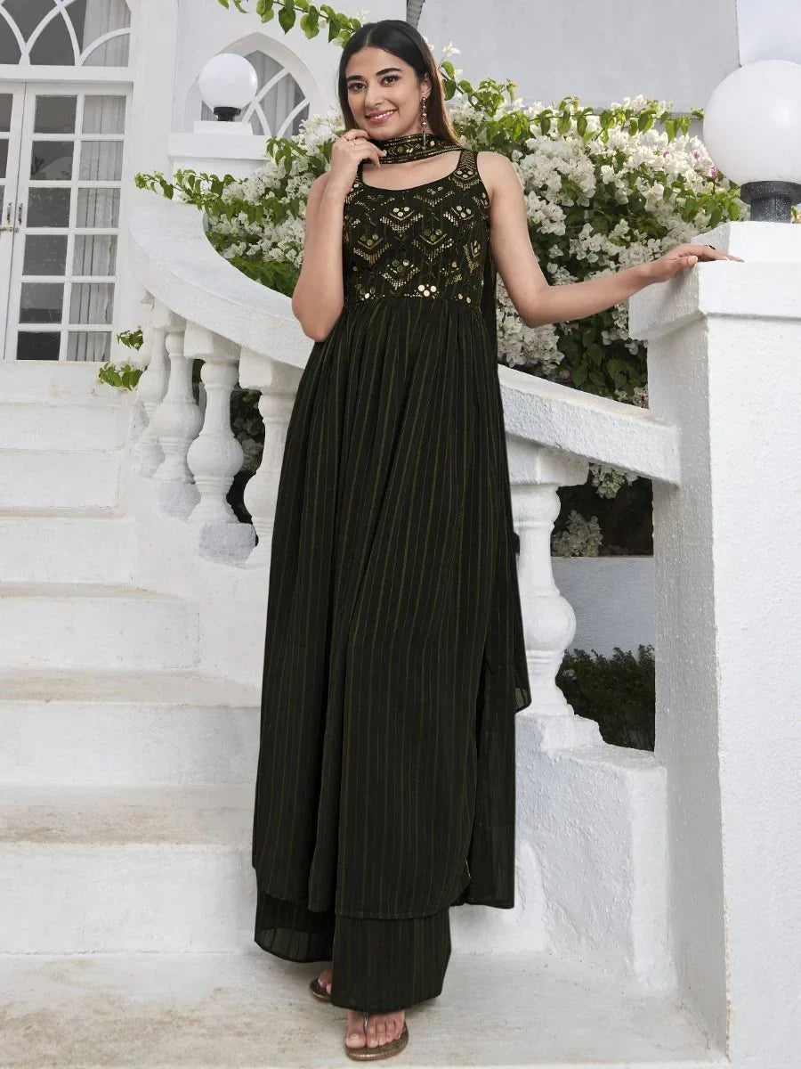 Woman in sleeveless black embroidered ethnic gown with dupatta, outdoor floral setting