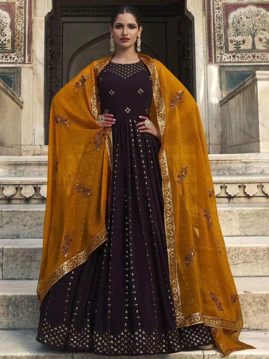 Woman in dark purple ethnic gown with gold embroidery and mustard yellow dupatta
