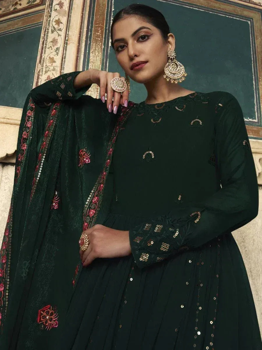 Elegant green embroidered ethnic gown with floral details and sequins, paired with statement jewelry.