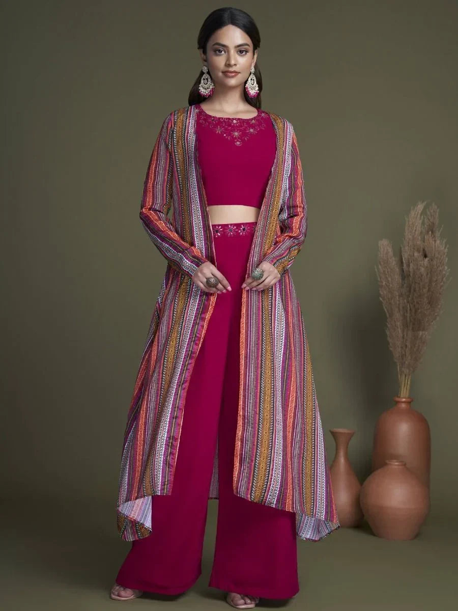 Woman wearing magenta ethnic palazzo set with colorful printed shrug, standing indoors
