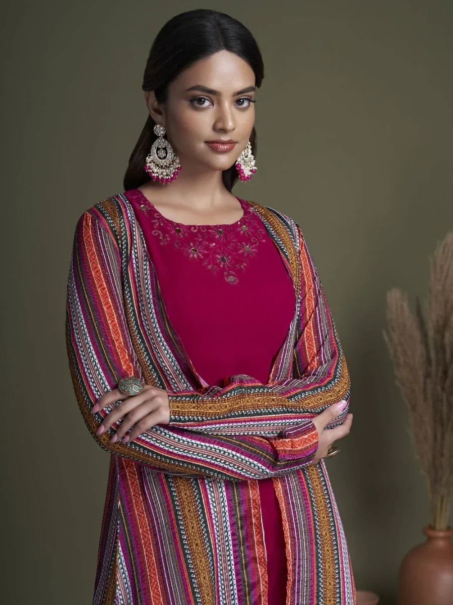 Woman in embroidered magenta Indian ethnic suit with colorful striped dupatta and statement earrings