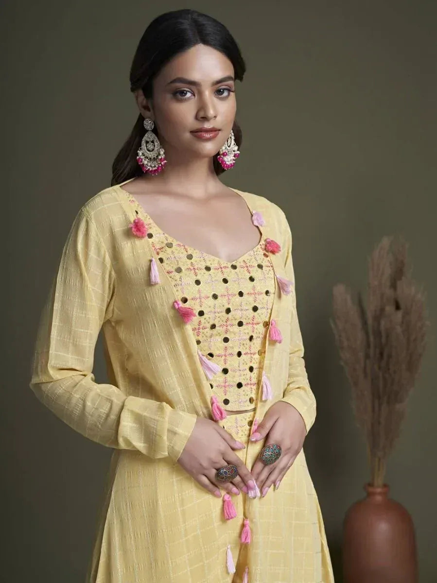 Woman in yellow ethnic kurti with pink tassels, statement earrings and rings