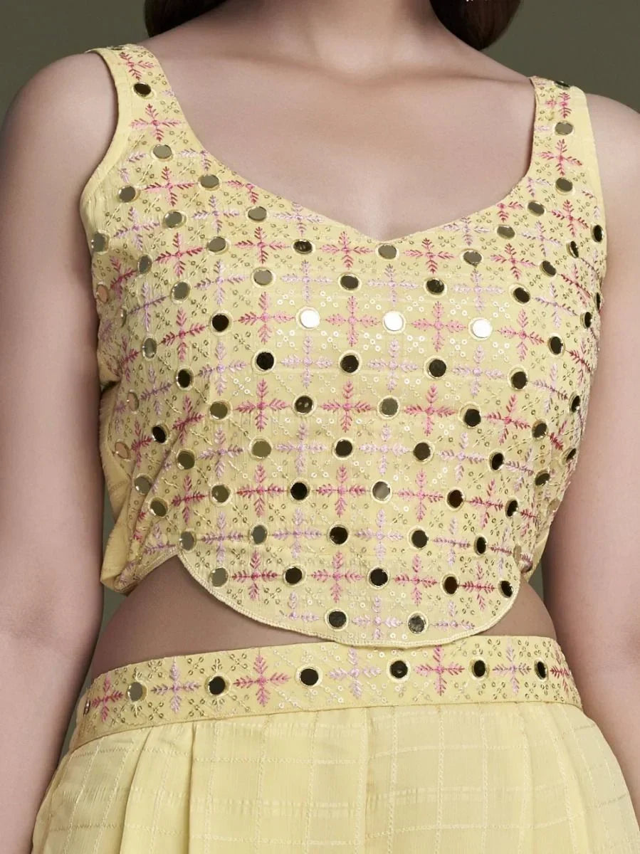 Yellow embroidered mirror work lehenga choli blouse with sleeveless design, close-up view