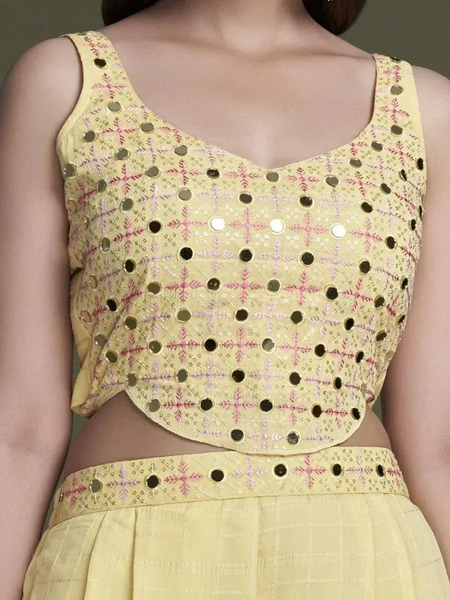 Yellow embroidered mirror work lehenga choli blouse with sleeveless design, close-up view