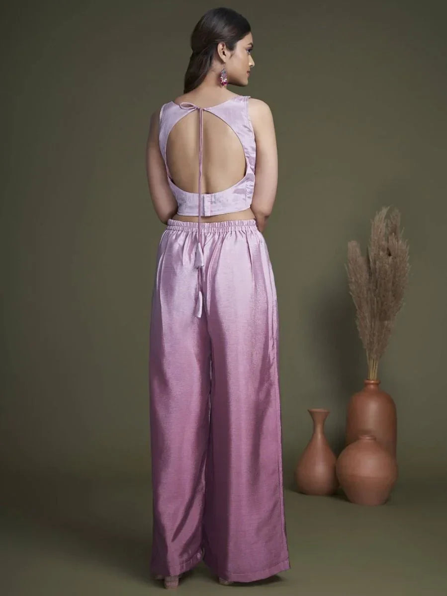 Woman in a mauve satin palazzo set with sleeveless open back blouse, styled indoors