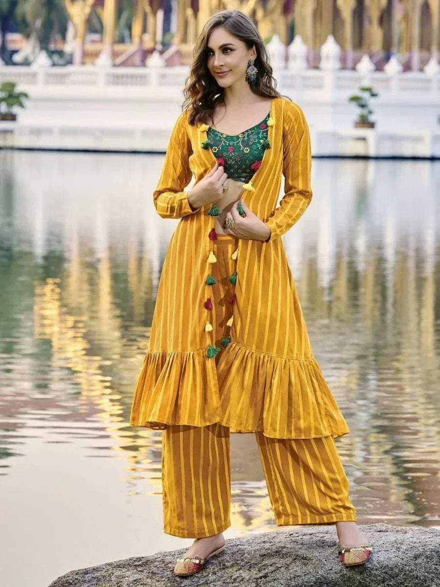 Woman wearing yellow striped ethnic kurta set with embroidered blouse, standing by a pond