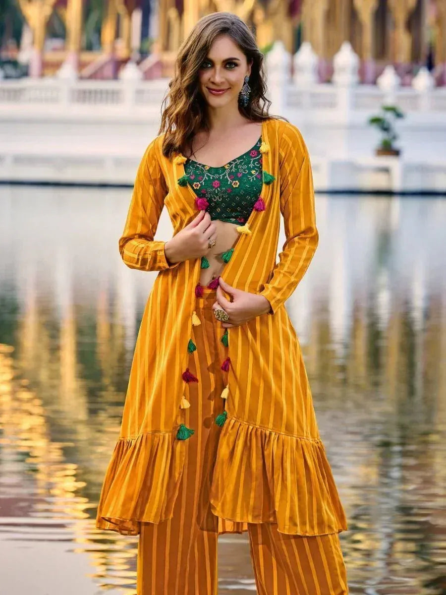 Woman in mustard yellow striped ethnic palazzo set with green embroidered crop top, outdoor setting