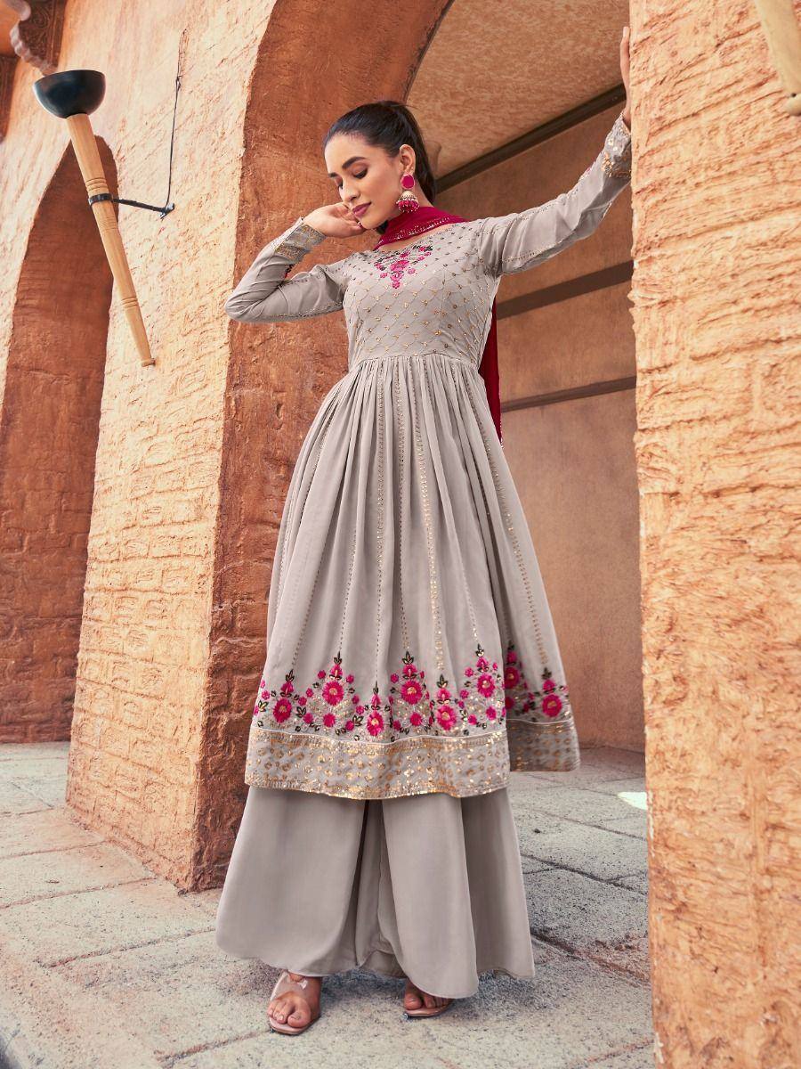 Woman wearing a grey embroidered Anarkali palazzo suit with floral and gold detailing
