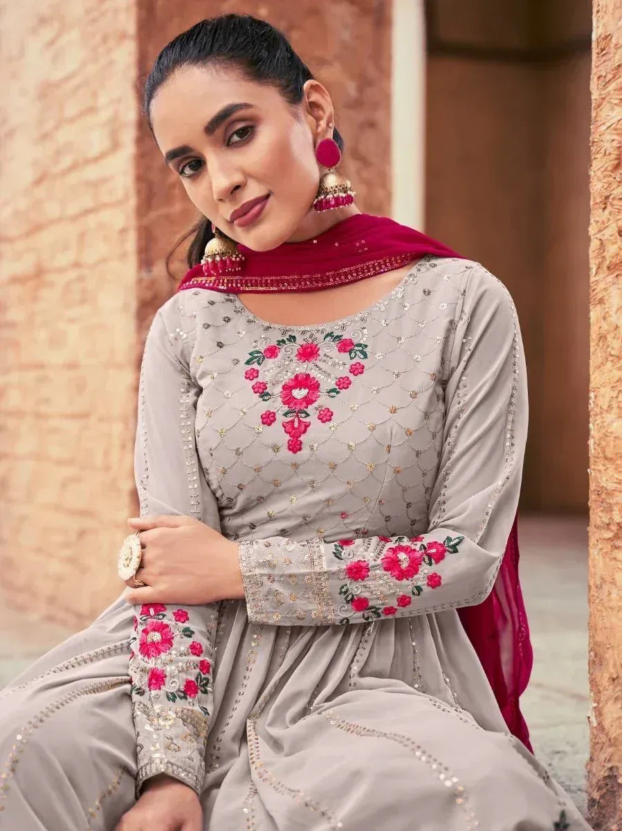 Woman in grey salwar kameez with red floral embroidery and maroon dupatta