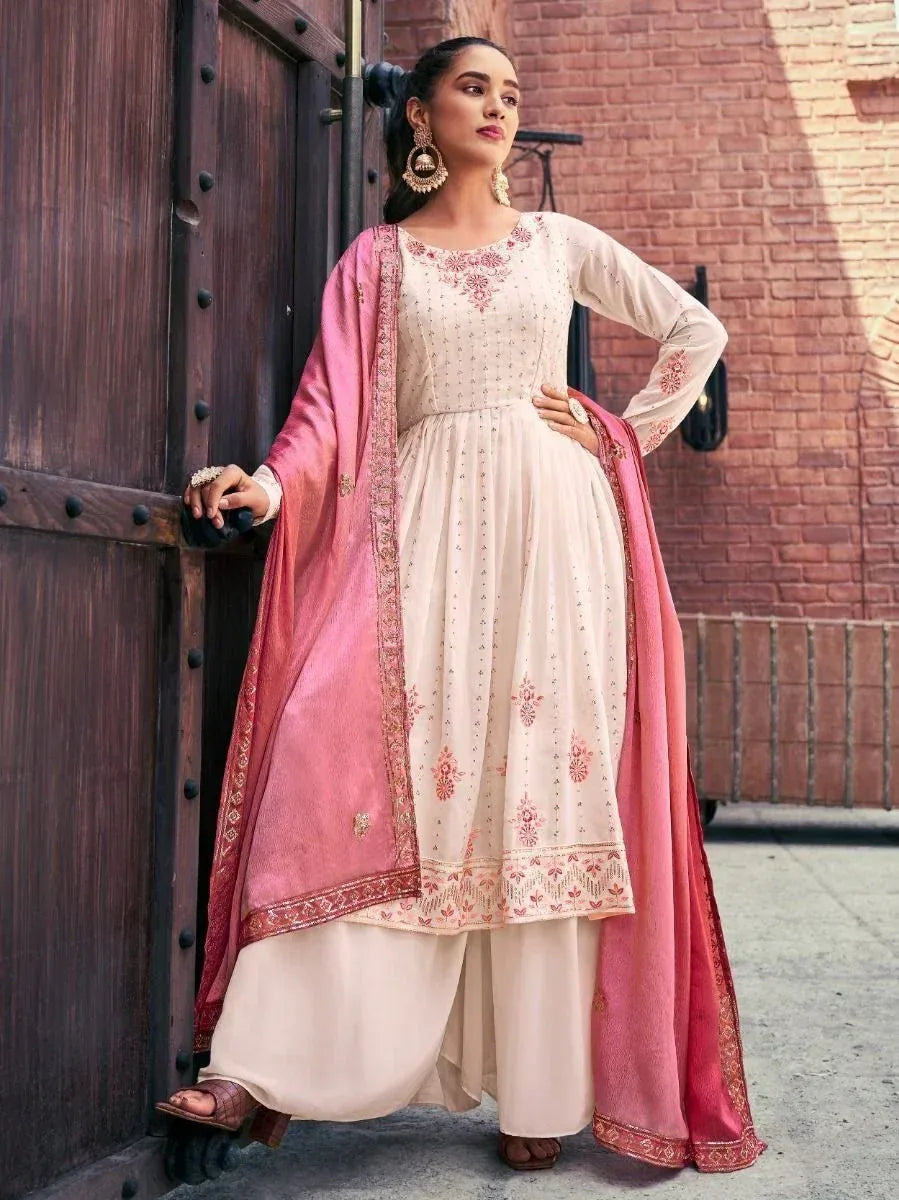 Woman in cream embroidered salwar kameez with pink dupatta and ethnic jewelry