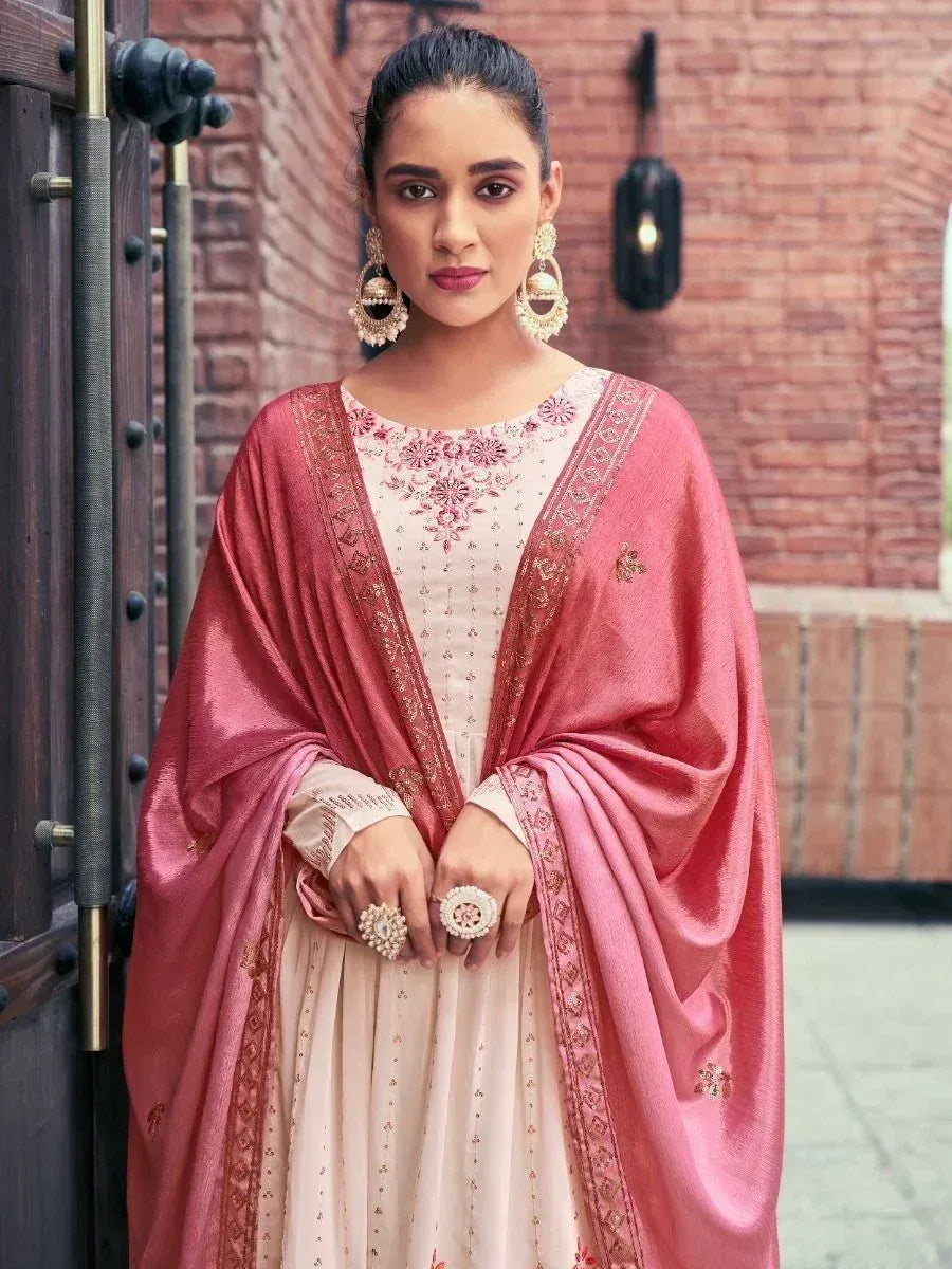 Woman in light pink embroidered salwar kameez with dupatta and statement jewelry