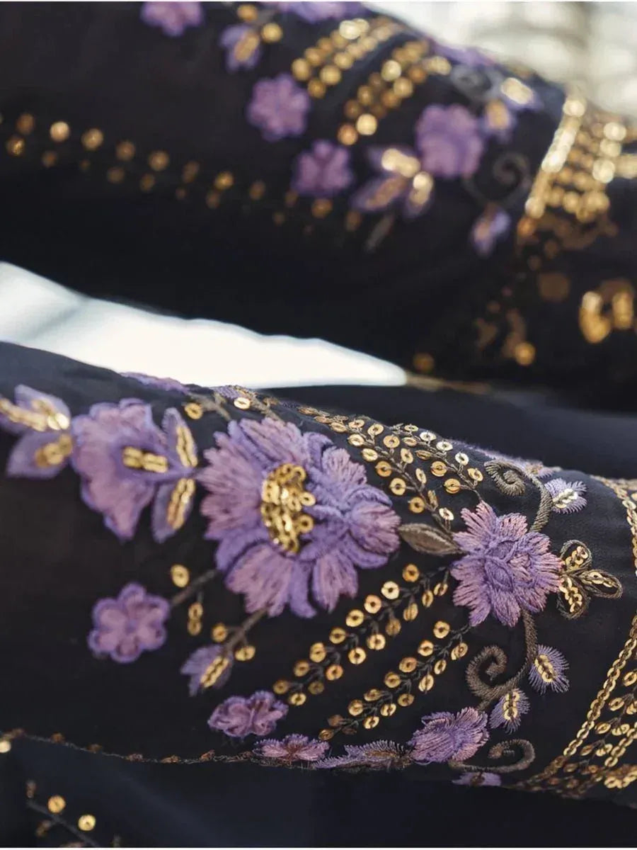 Black ethnic wear with purple floral embroidery and gold sequins, perfect for festive occasions.