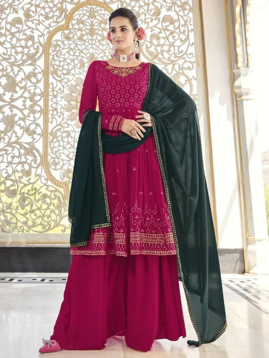 Woman wearing magenta palazzo salwar kameez with embroidery and dark green dupatta