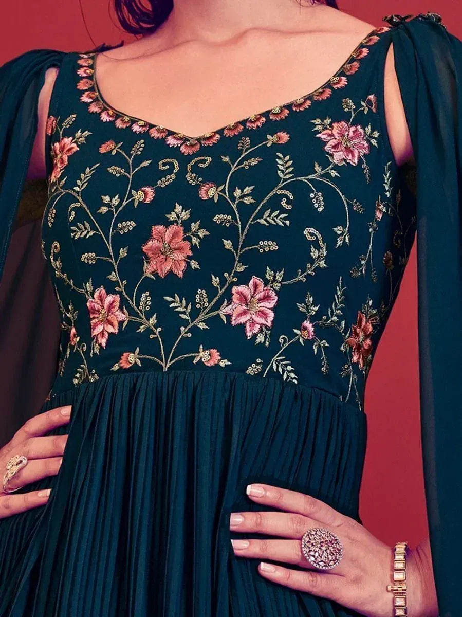 Dark green ethnic gown with pink floral embroidery and sheer sleeves, perfect for Indian occasions.
