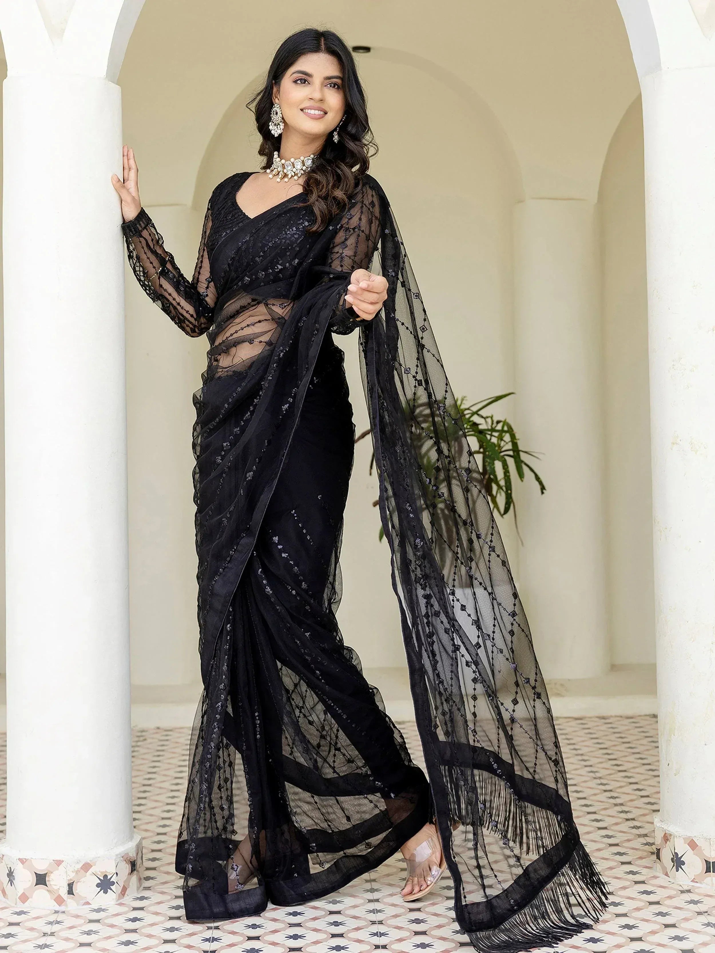 Black embroidered saree with sheer net blouse and fringe, styled for ethnic occasions