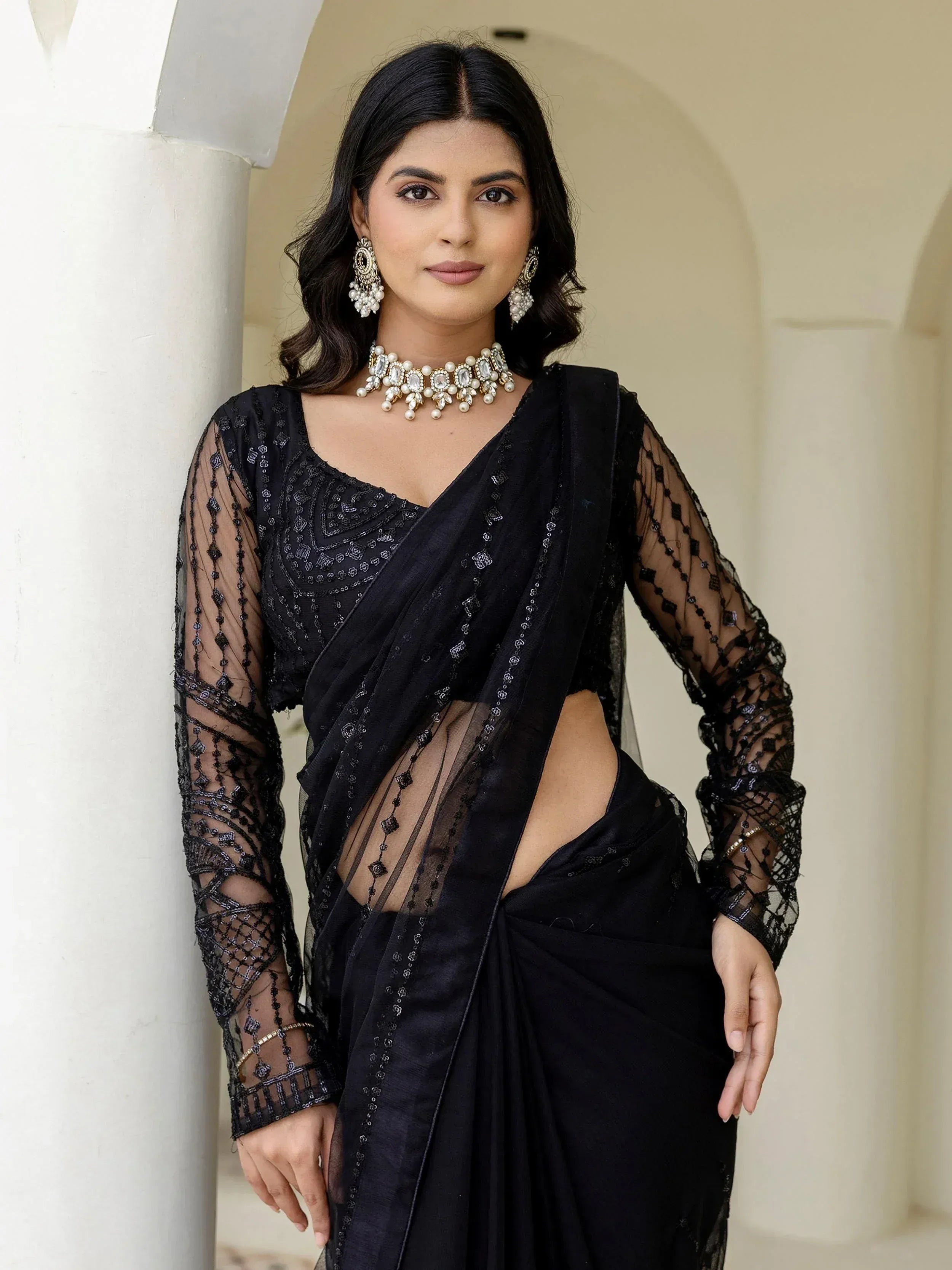 Black sheer saree with sequin embroidery, designer blouse, and statement jewelry for ethnic wear