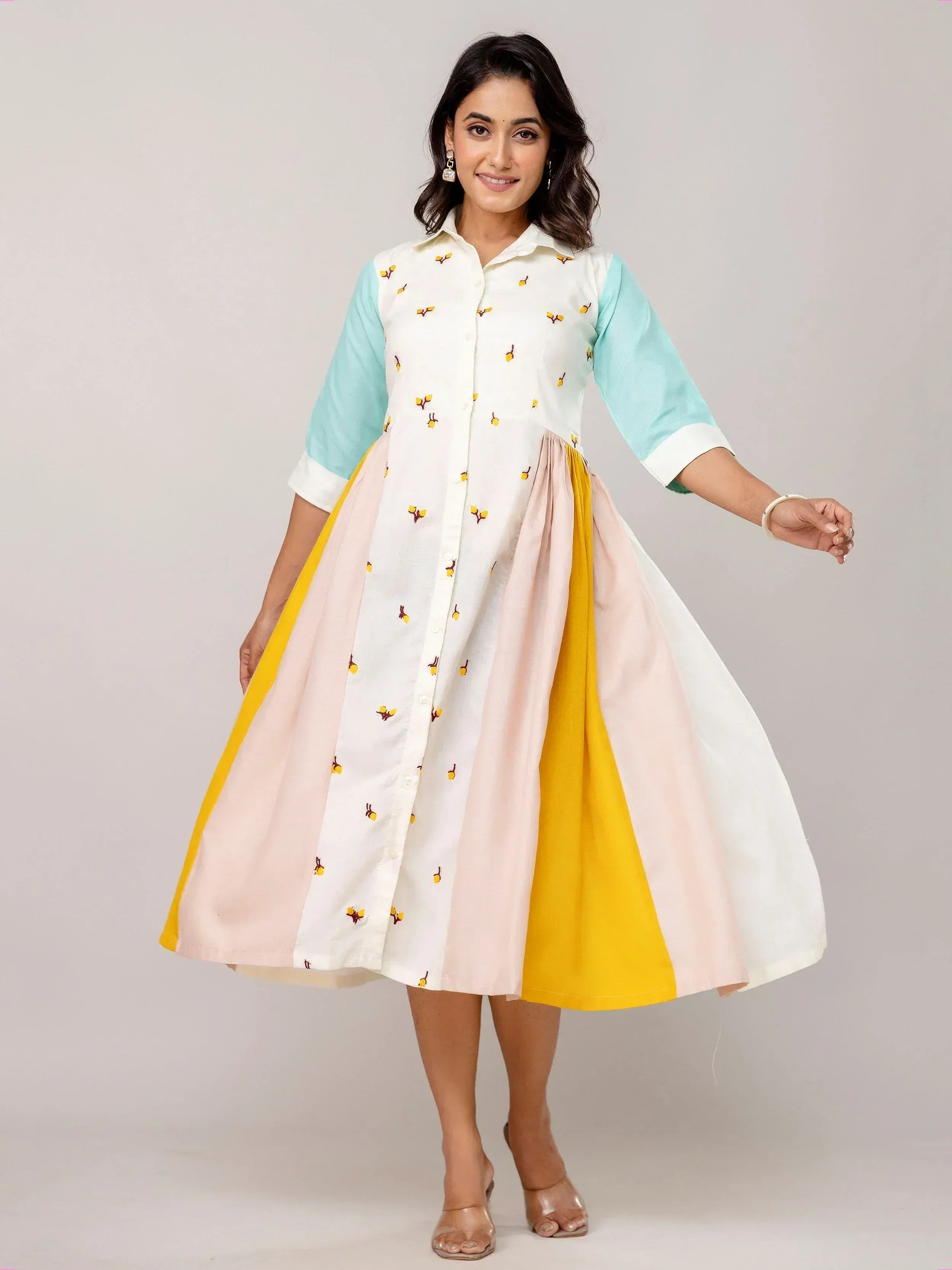 Woman in colorful embroidered ethnic gown with pastel sleeves and flared skirt, perfect for Indian festive wear.