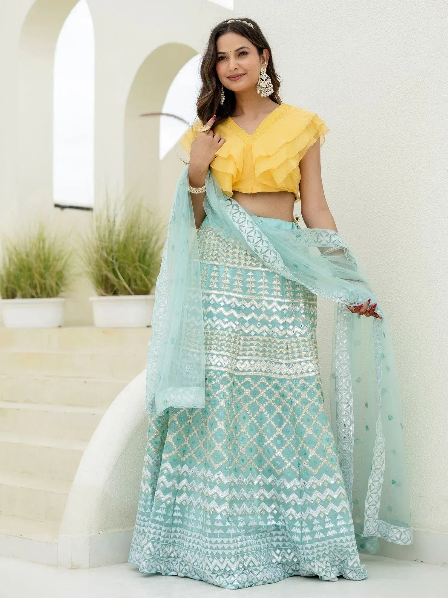 Yellow ruffle crop top with mint green embroidered lehenga choli, perfect for Indian ethnic wear occasions