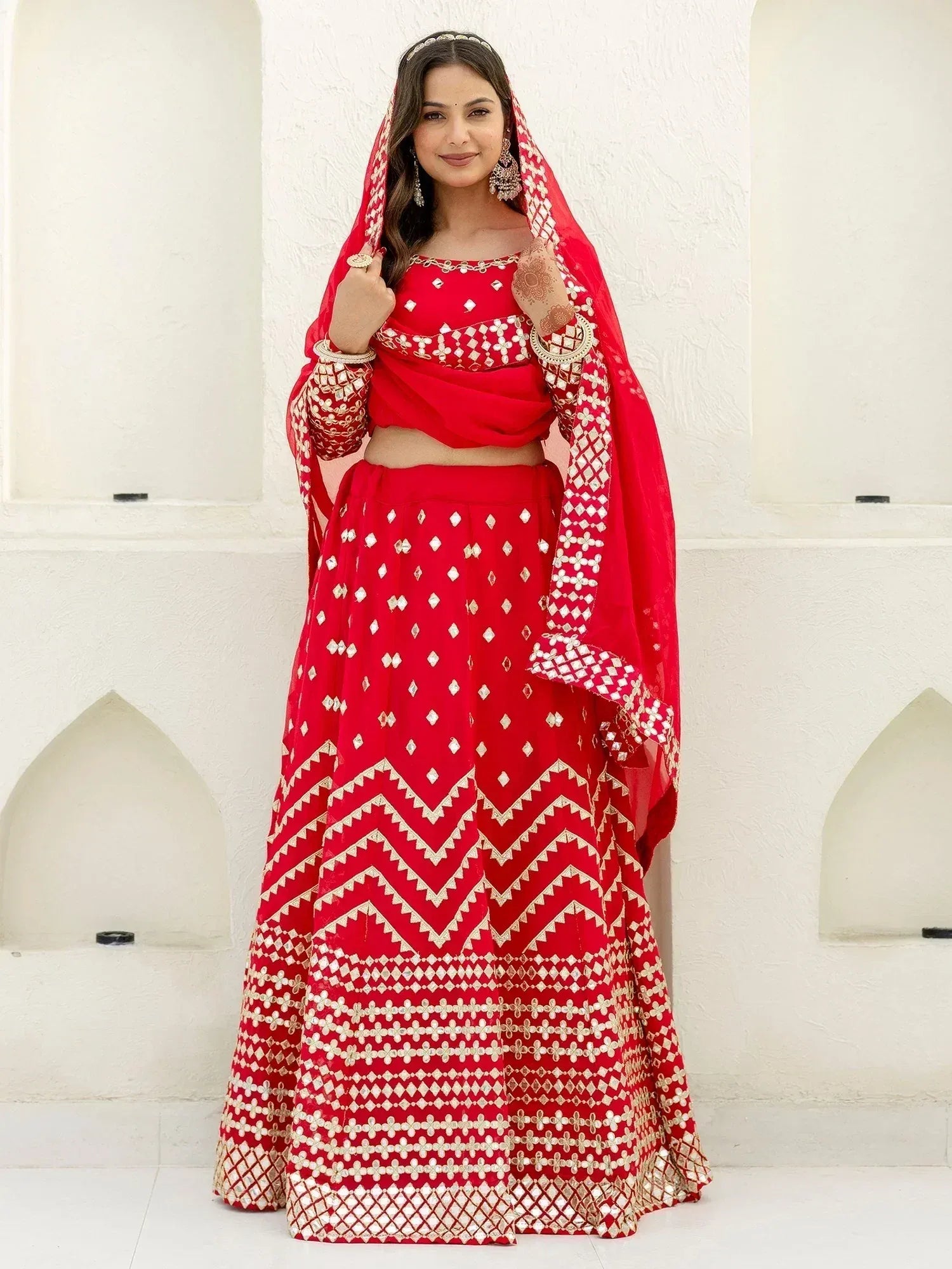 Red embroidered lehenga choli with mirror work and dupatta, perfect for Indian weddings and festivals