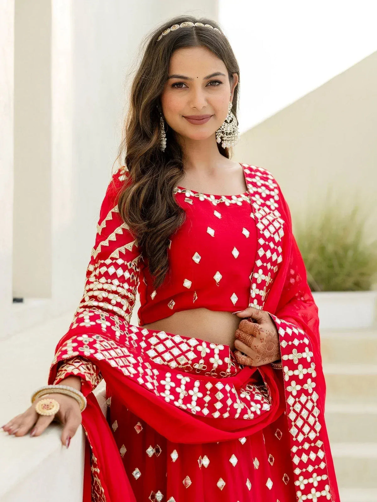Red embroidered lehenga choli with mirror work, perfect for Indian weddings and festive occasions