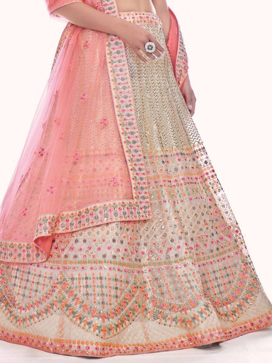 Pink and gold embroidered lehenga choli with floral mirror work, perfect for Indian weddings and festive occasions.
