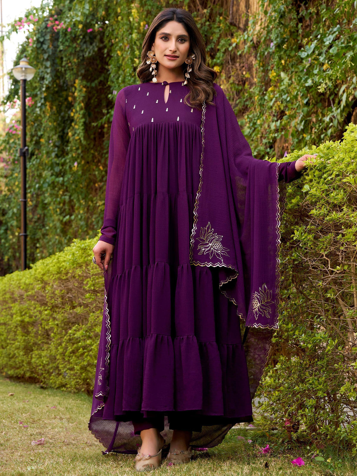 Purple tiered ethnic gown with gold floral embroidery, perfect for Indian occasions
