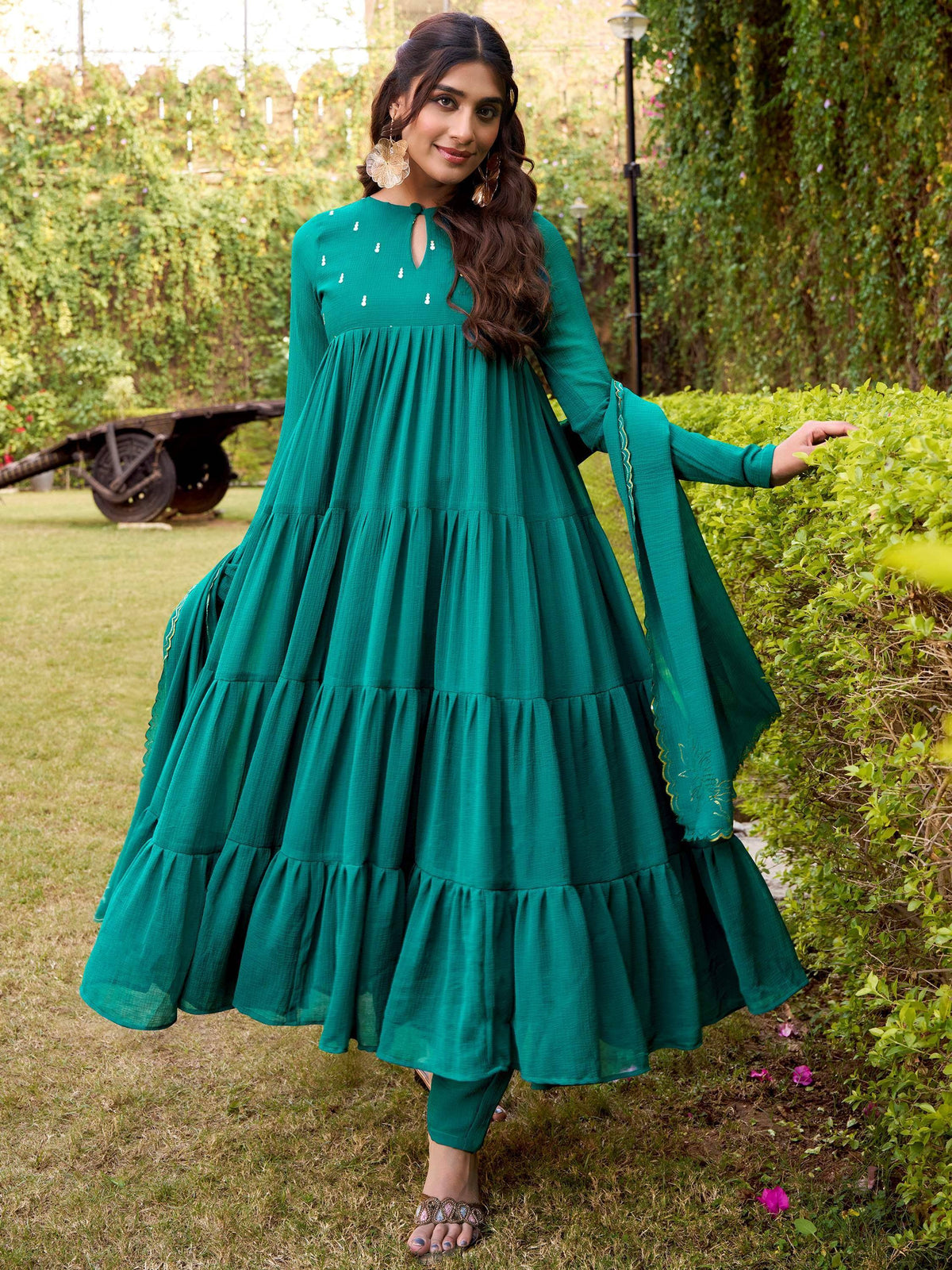 Emerald green tiered ethnic gown with flared sleeves, perfect for Indian festive occasions.