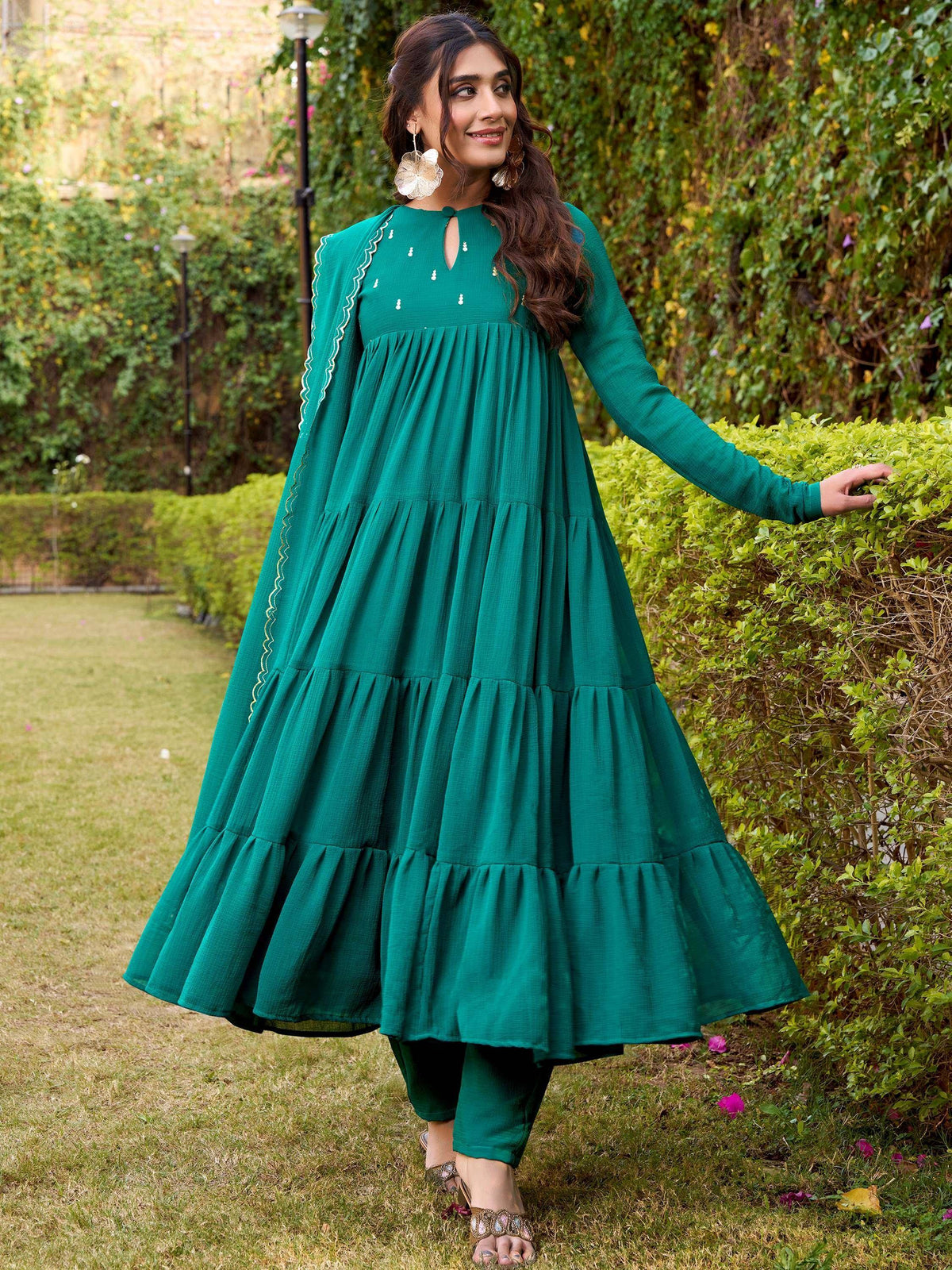 Emerald green tiered ethnic gown with scalloped sleeves, perfect for festive occasions and Indian wear.