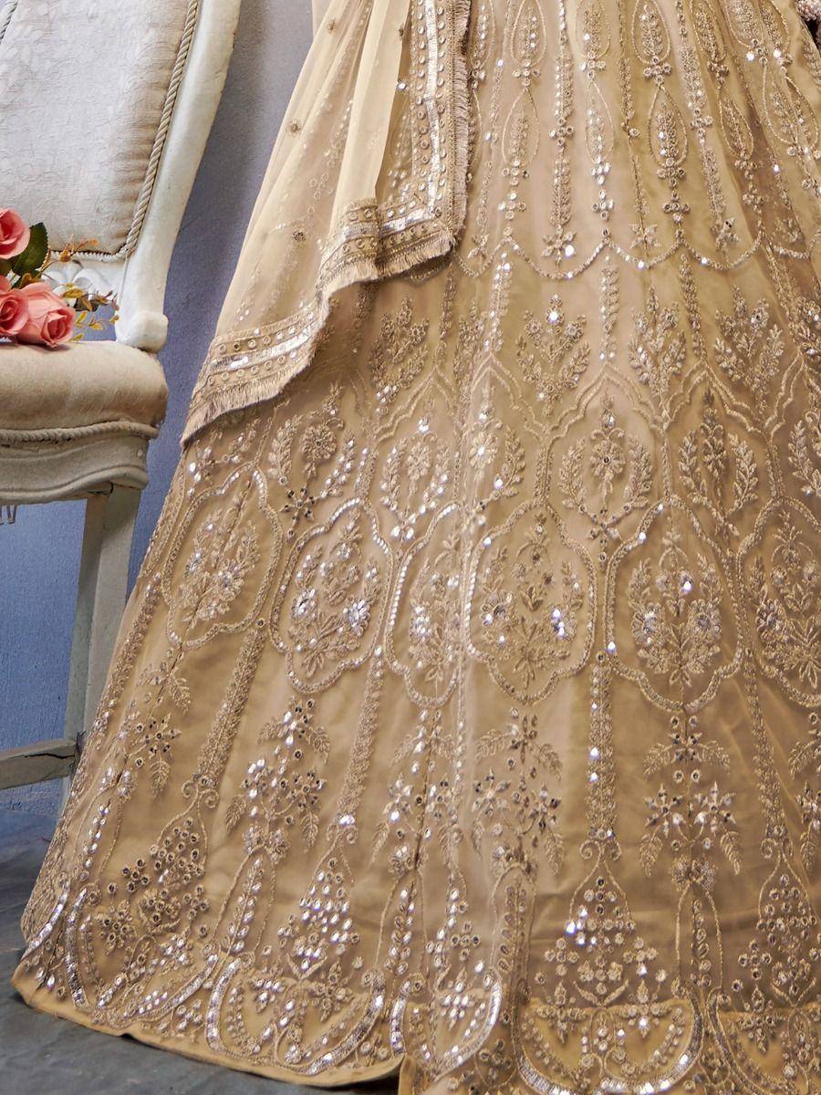 Gold embroidered lehenga choli with intricate mirror work and floral motifs, perfect for Indian weddings