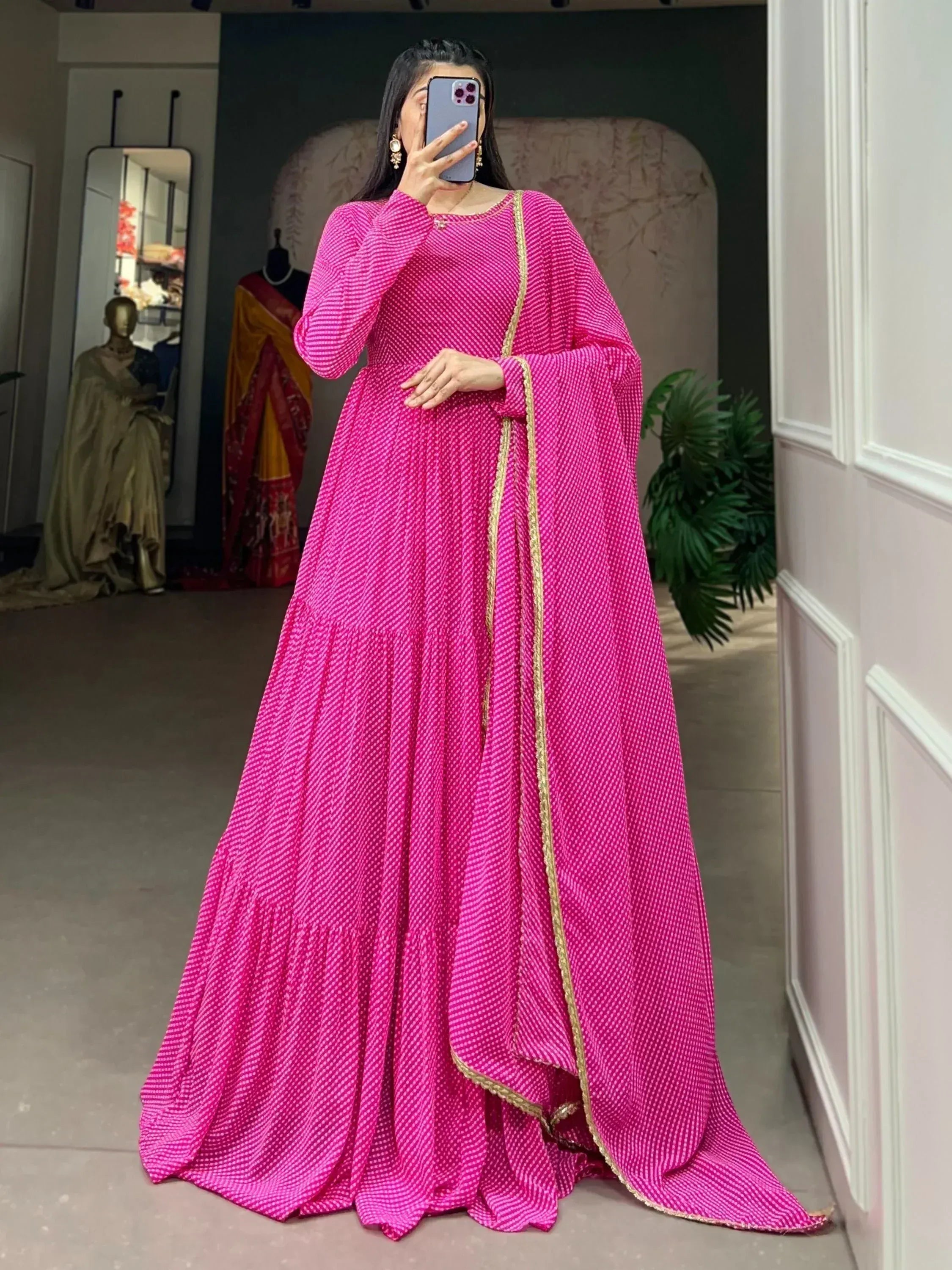 Pink ethnic gown with gold trim, long sleeves, and flared skirt for Indian wear