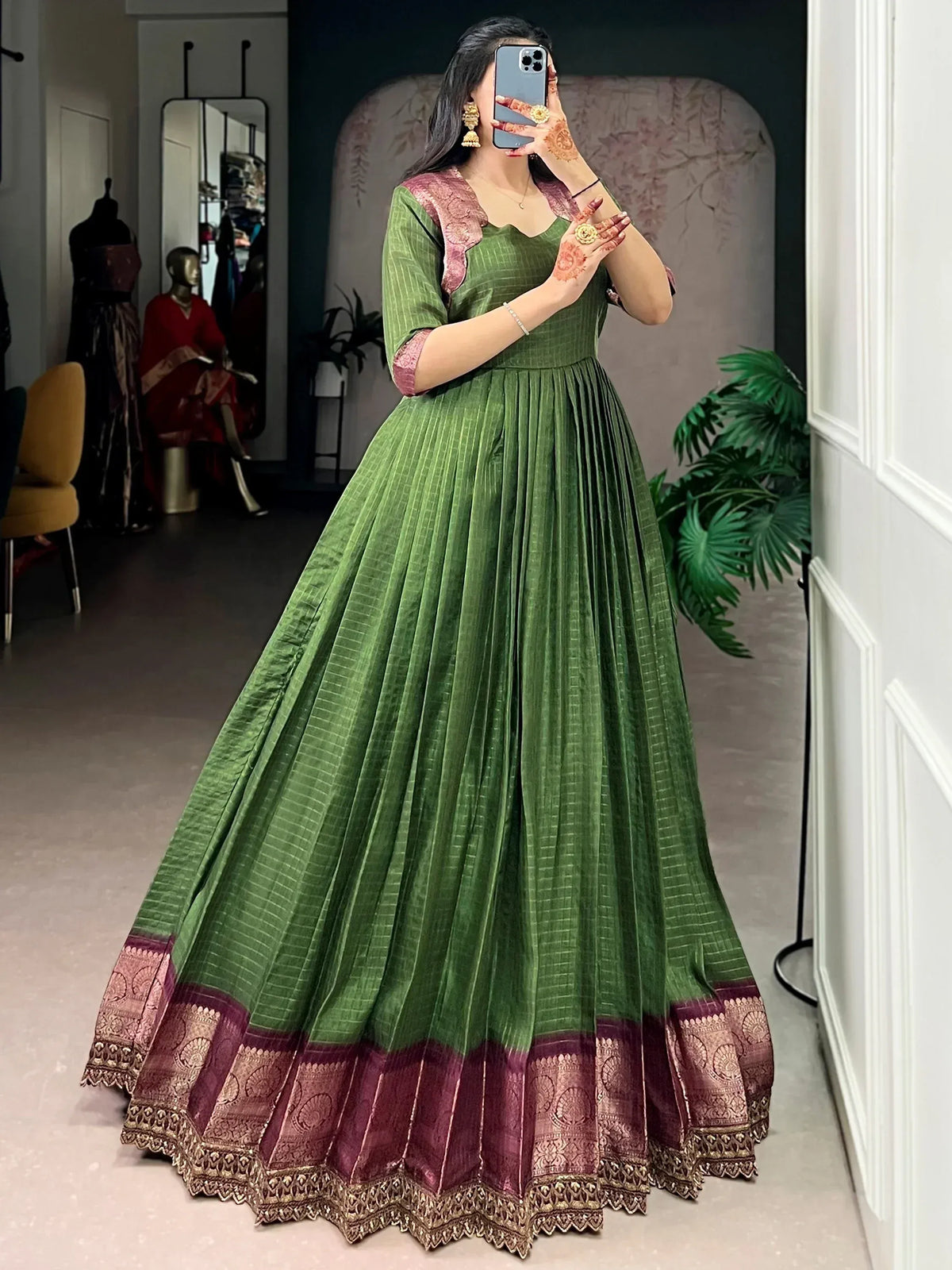 Green ethnic gown with pink gold border, pleated skirt, perfect for Indian weddings or festive occasions.
