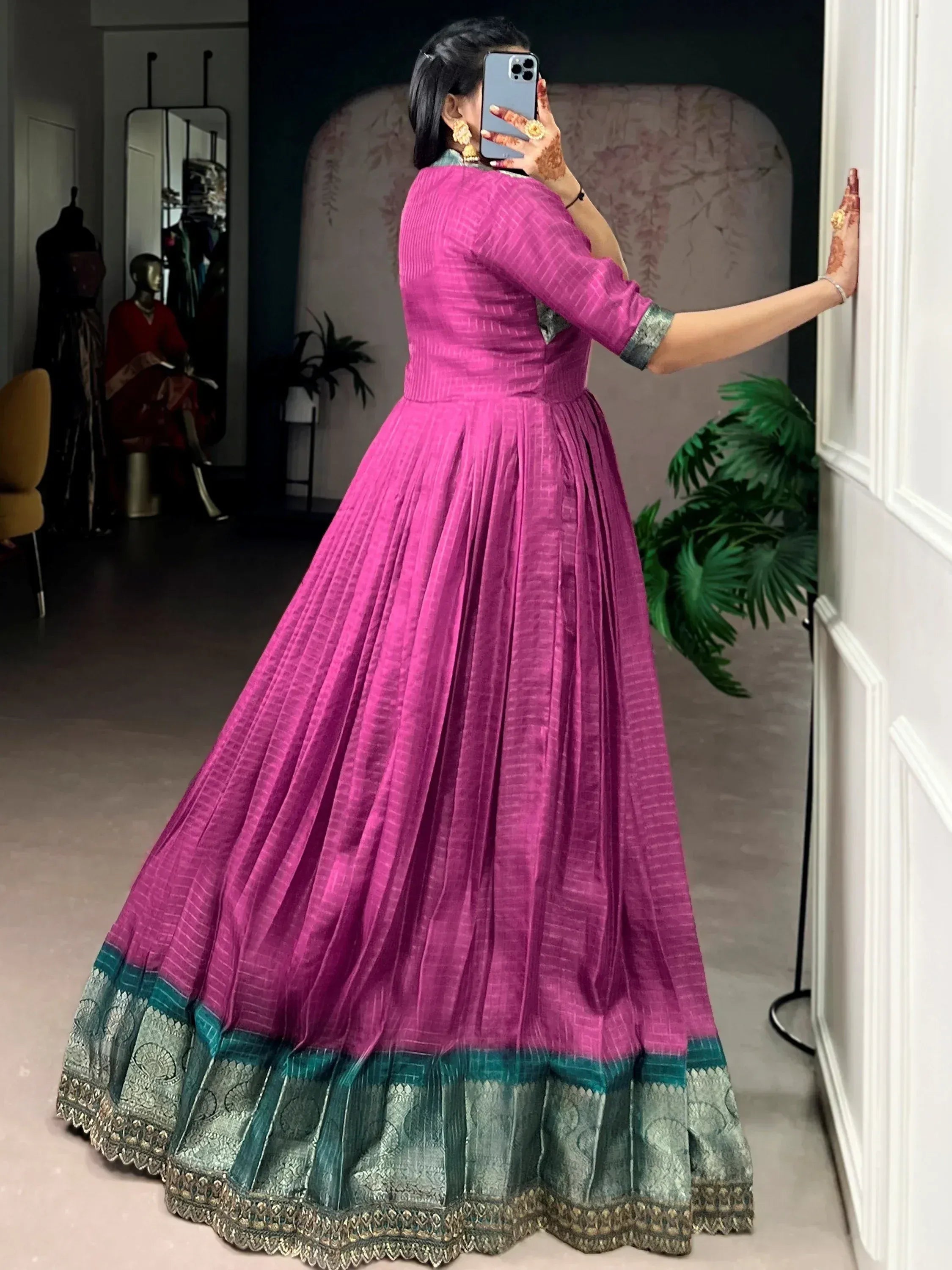 Vibrant pink ethnic gown with green border, perfect for Indian occasions and festive wear.
