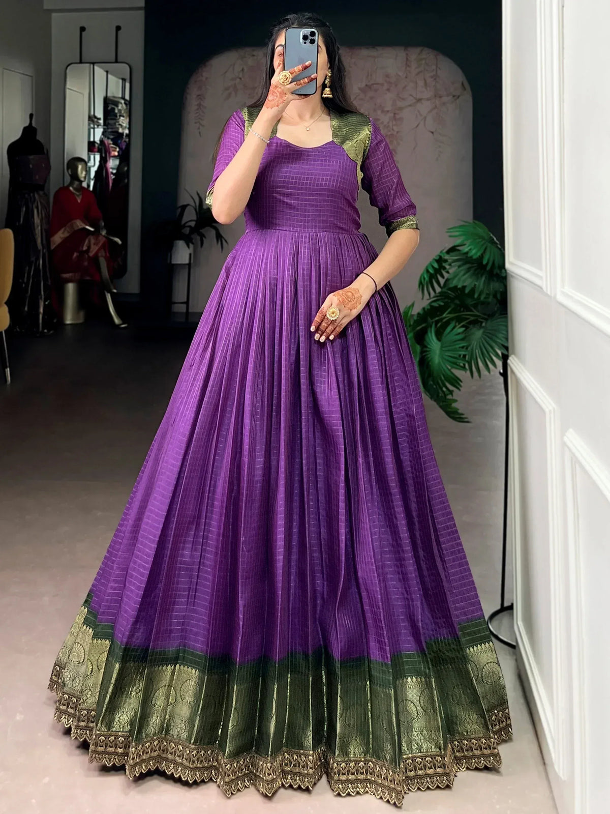 Purple and green ethnic gown with pleated skirt and gold border, perfect for Indian occasions