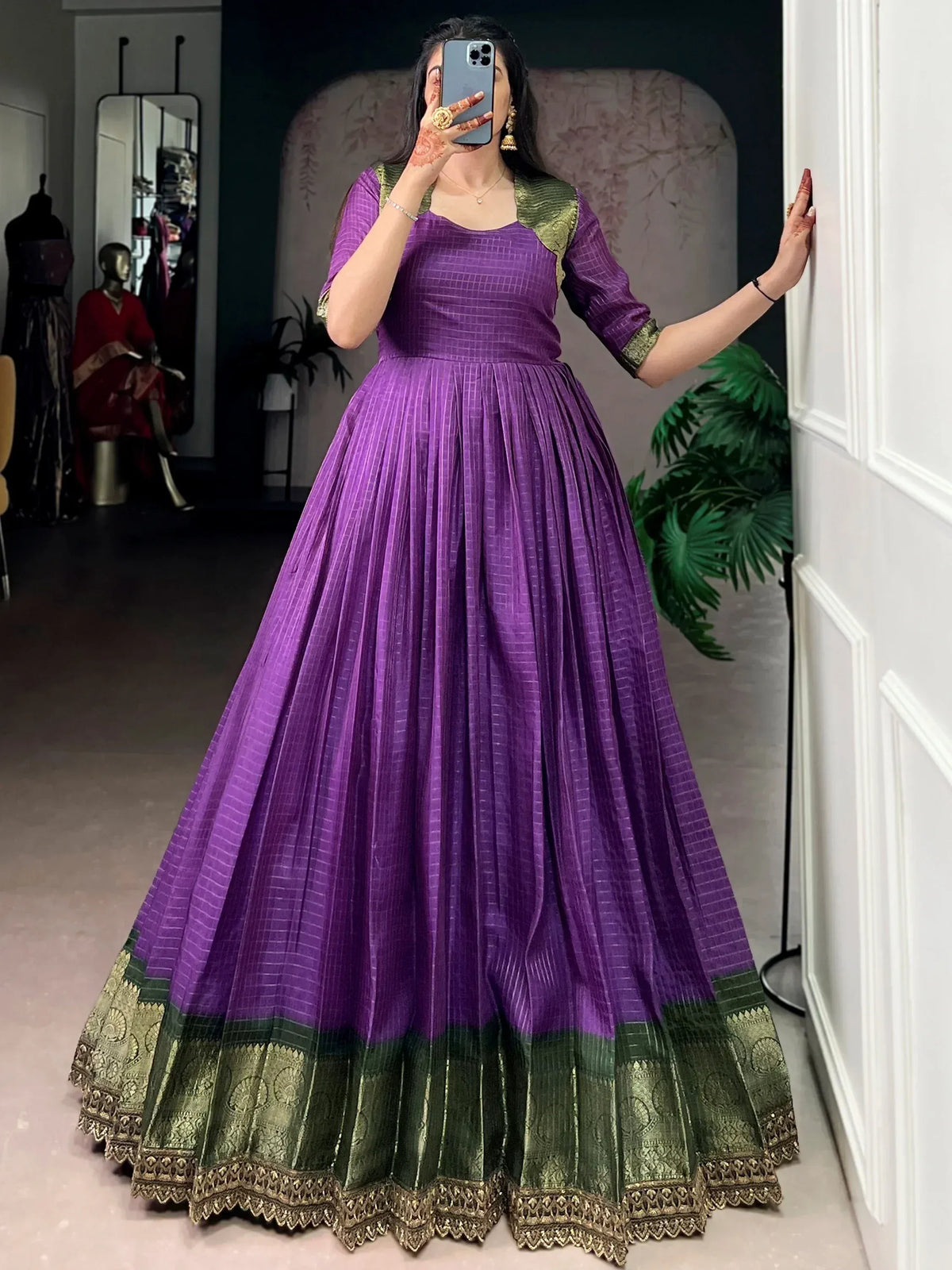 Purple and green ethnic gown with pleated skirt and gold border, perfect for Indian occasions