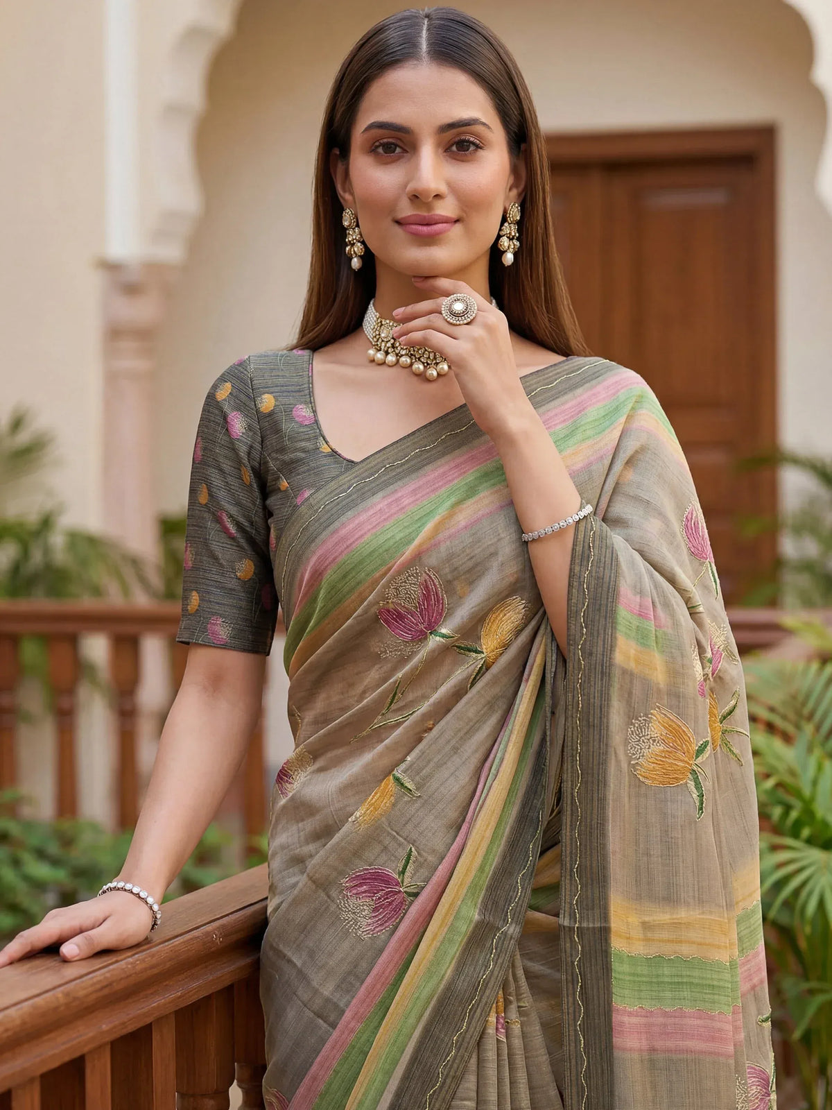 Woman wearing a grey floral embroidered Indian ethnic saree with a matching blouse
