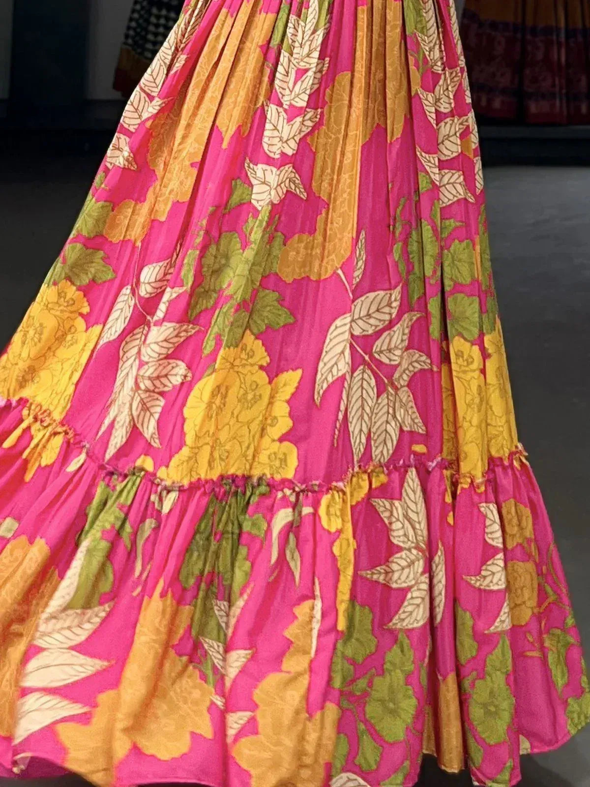 Vibrant pink floral lehenga skirt with yellow and green leaf print, pleated design for ethnic wear
