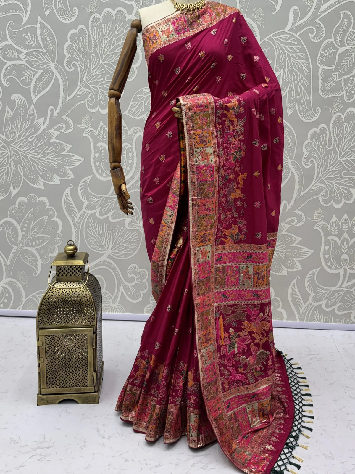 Deep magenta Banarasi silk saree with gold zari floral borders on a mannequin