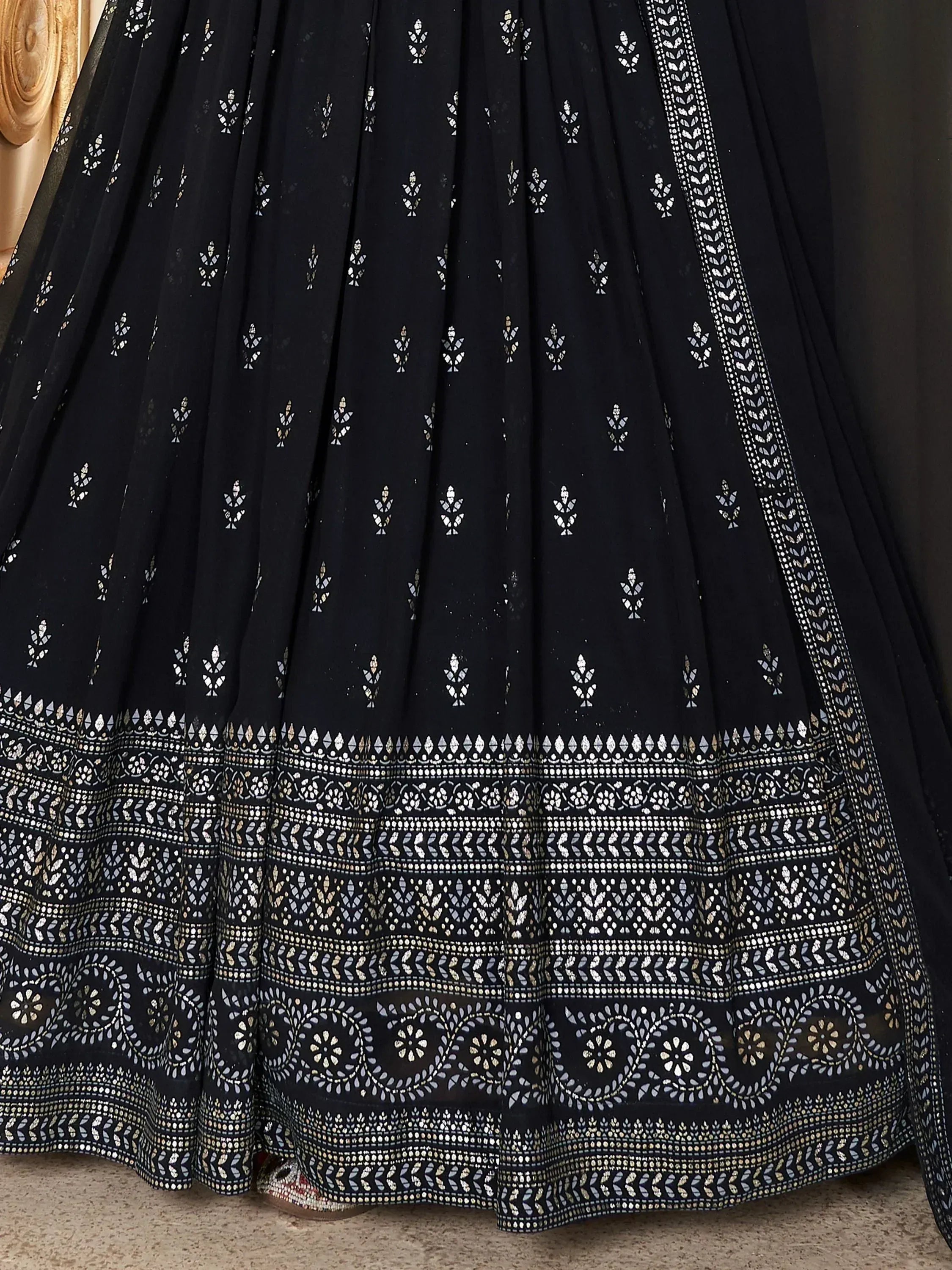 Black ethnic lehenga with silver mirror work and intricate border design, perfect for Indian weddings and festive occasions.