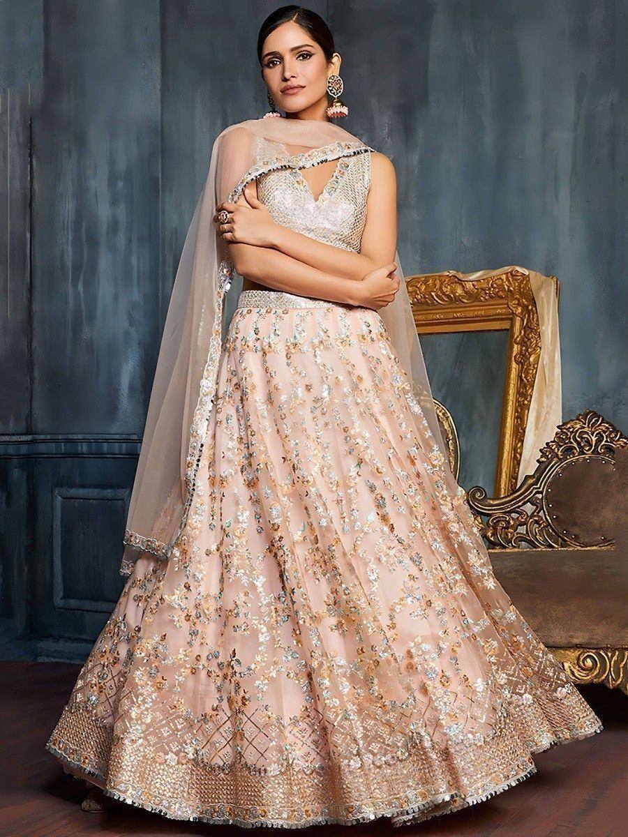 Elegant blush pink lehenga choli with floral embroidery and sheer dupatta, perfect for Indian weddings and festive occasions.