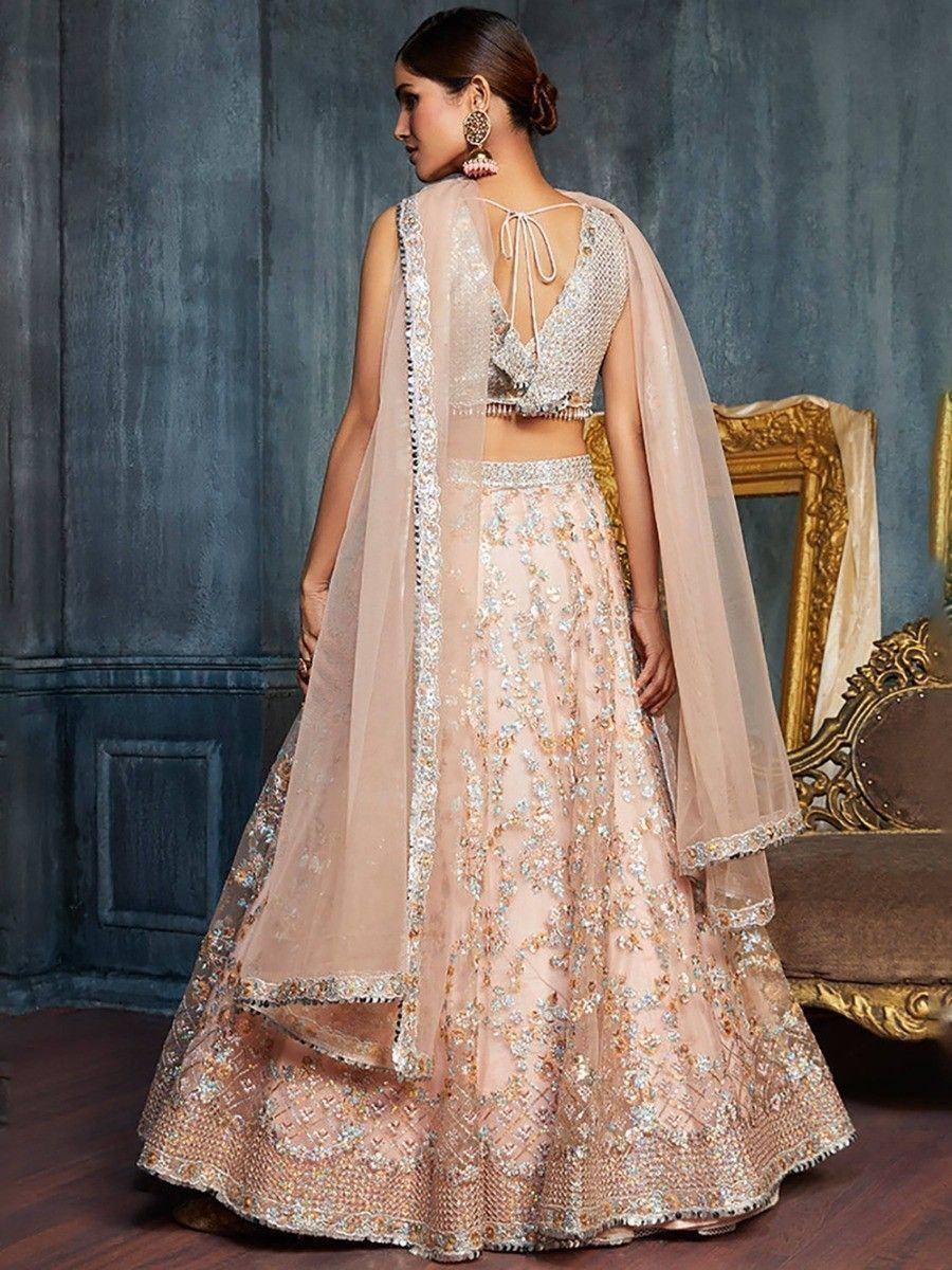 Elegant blush pink lehenga choli with intricate embroidery and sheer dupatta, perfect for Indian weddings or festive occasions.