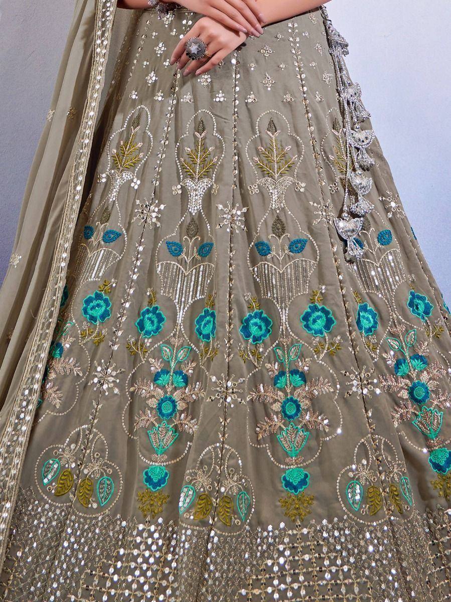 Olive green lehenga with teal floral embroidery and silver mirror work, perfect for Indian weddings or festive occasions.