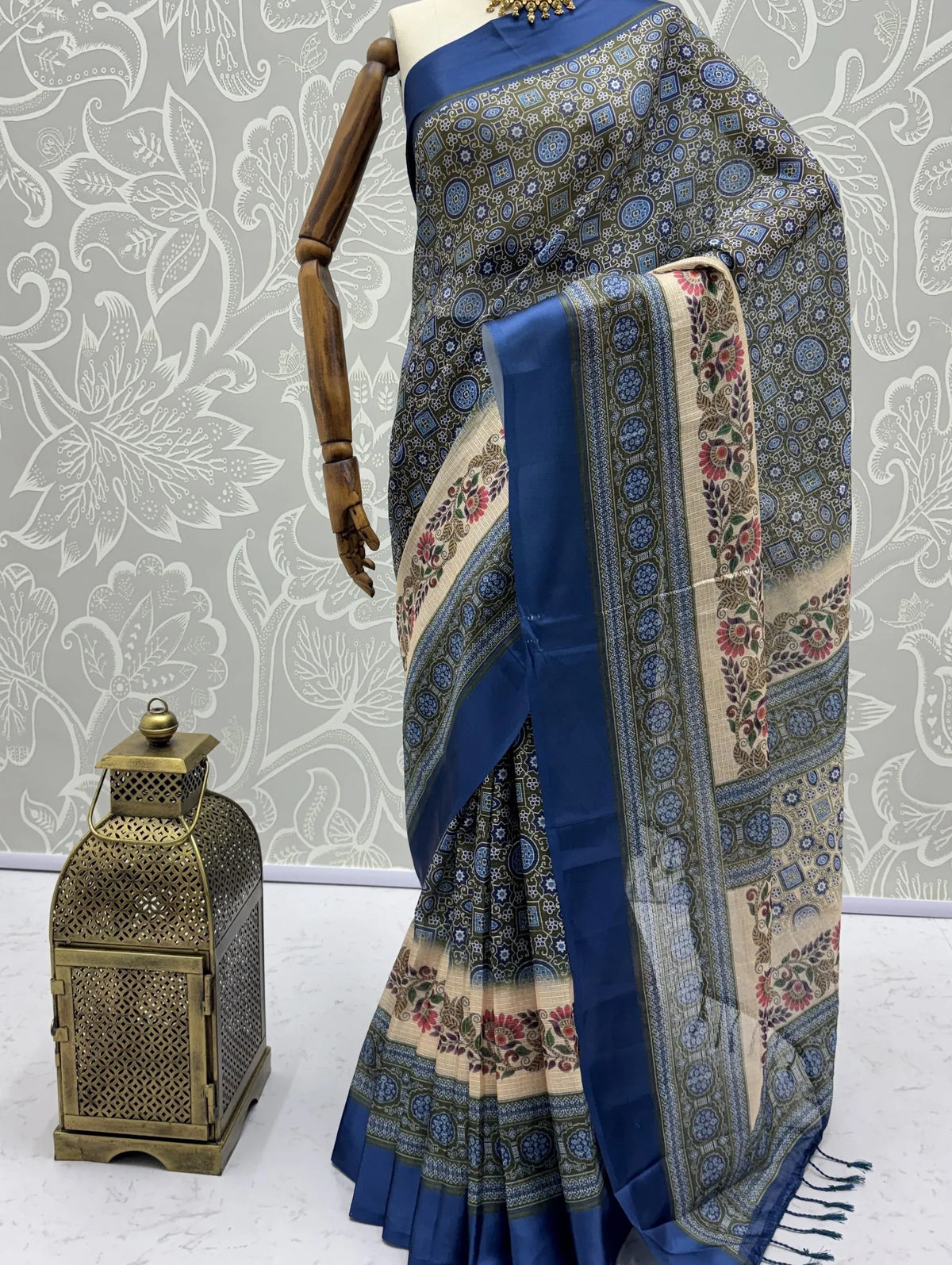 Blue and beige printed Indian ethnic saree draped on a mannequin with a decorative lantern.