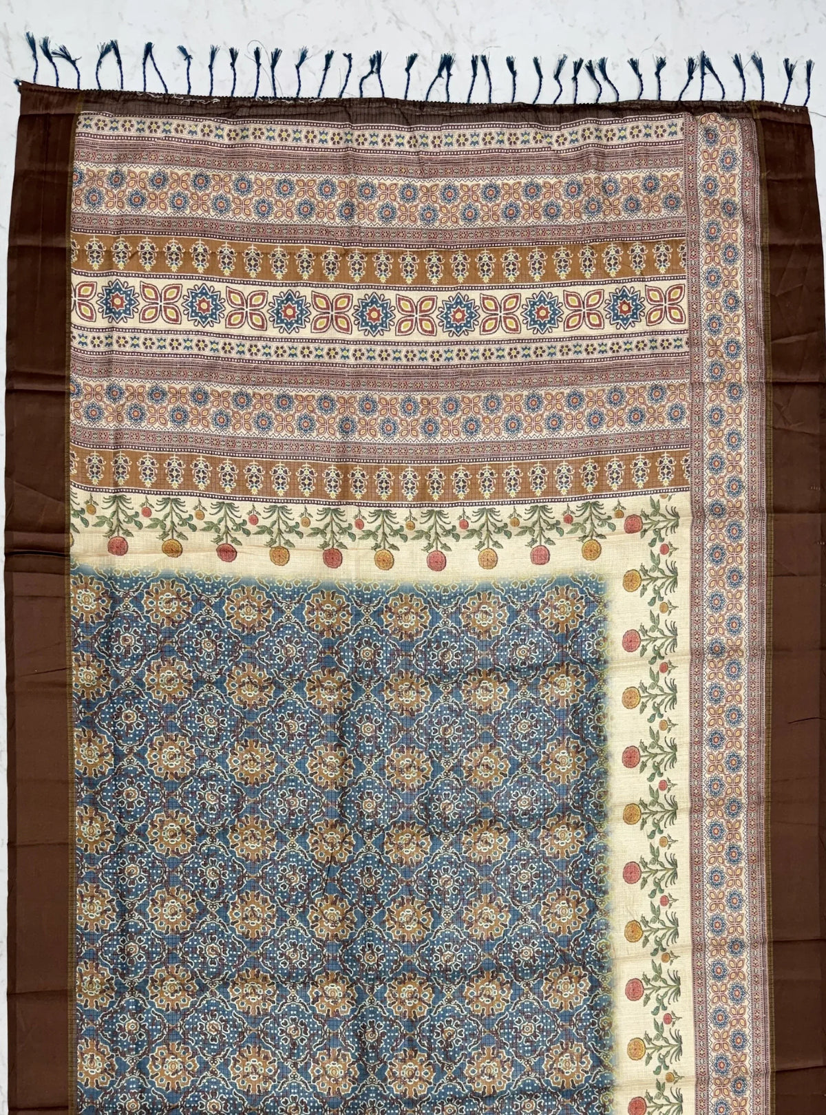 Blue and brown patterned Indian ethnic fabric with intricate floral borders and tassels