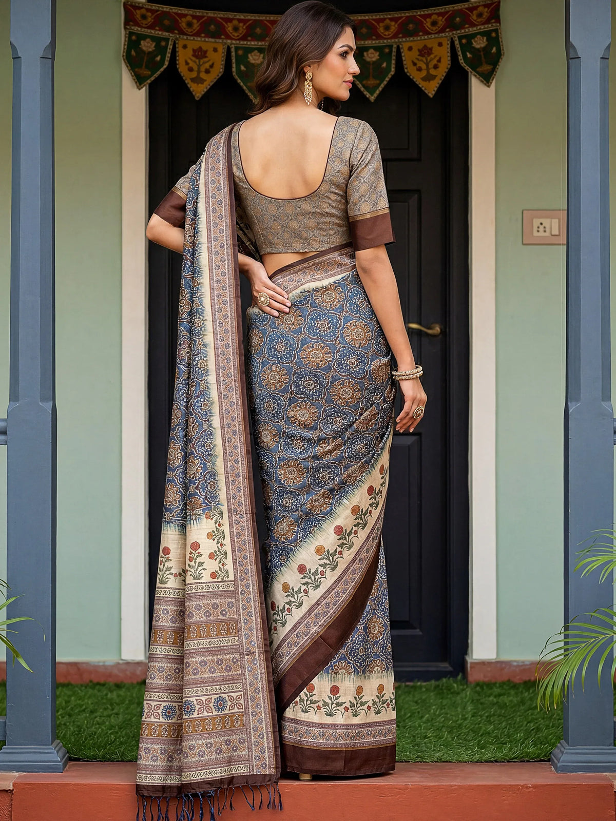 Woman wearing a blue and brown patterned designer saree with a matching blouse