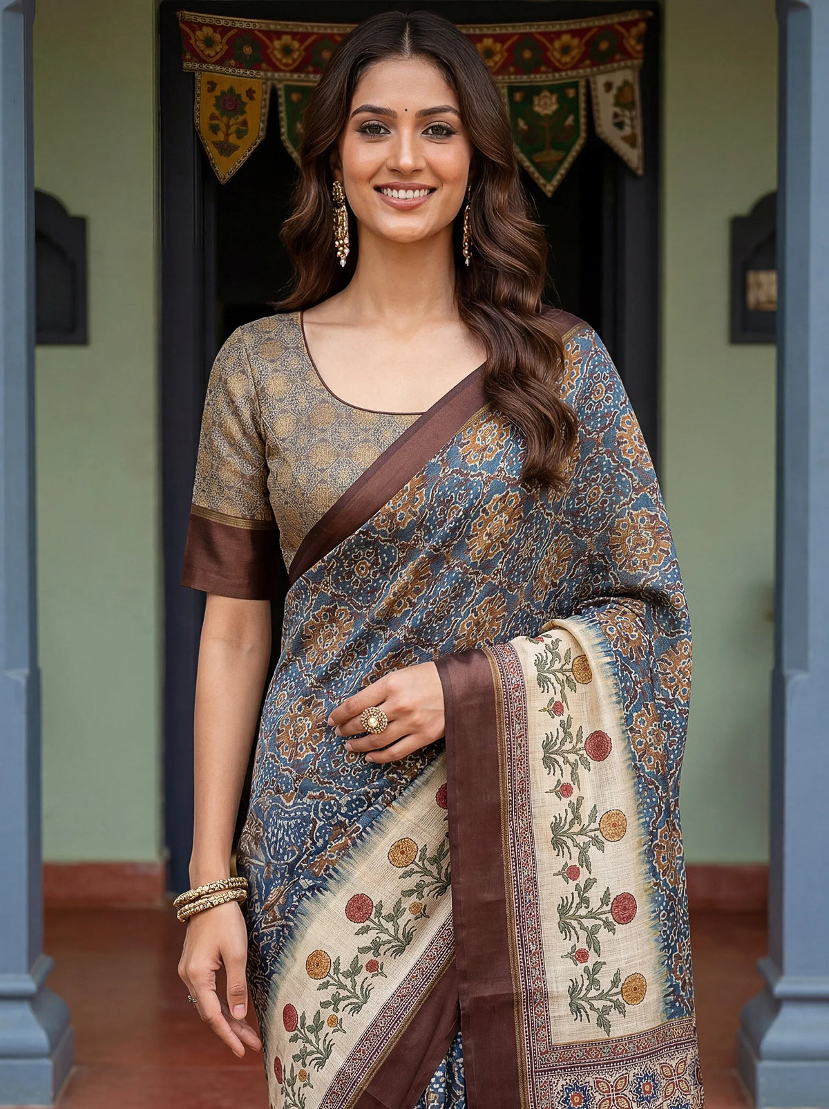 Woman wearing a grey floral print ethnic saree with a contrasting brown border and blouse.