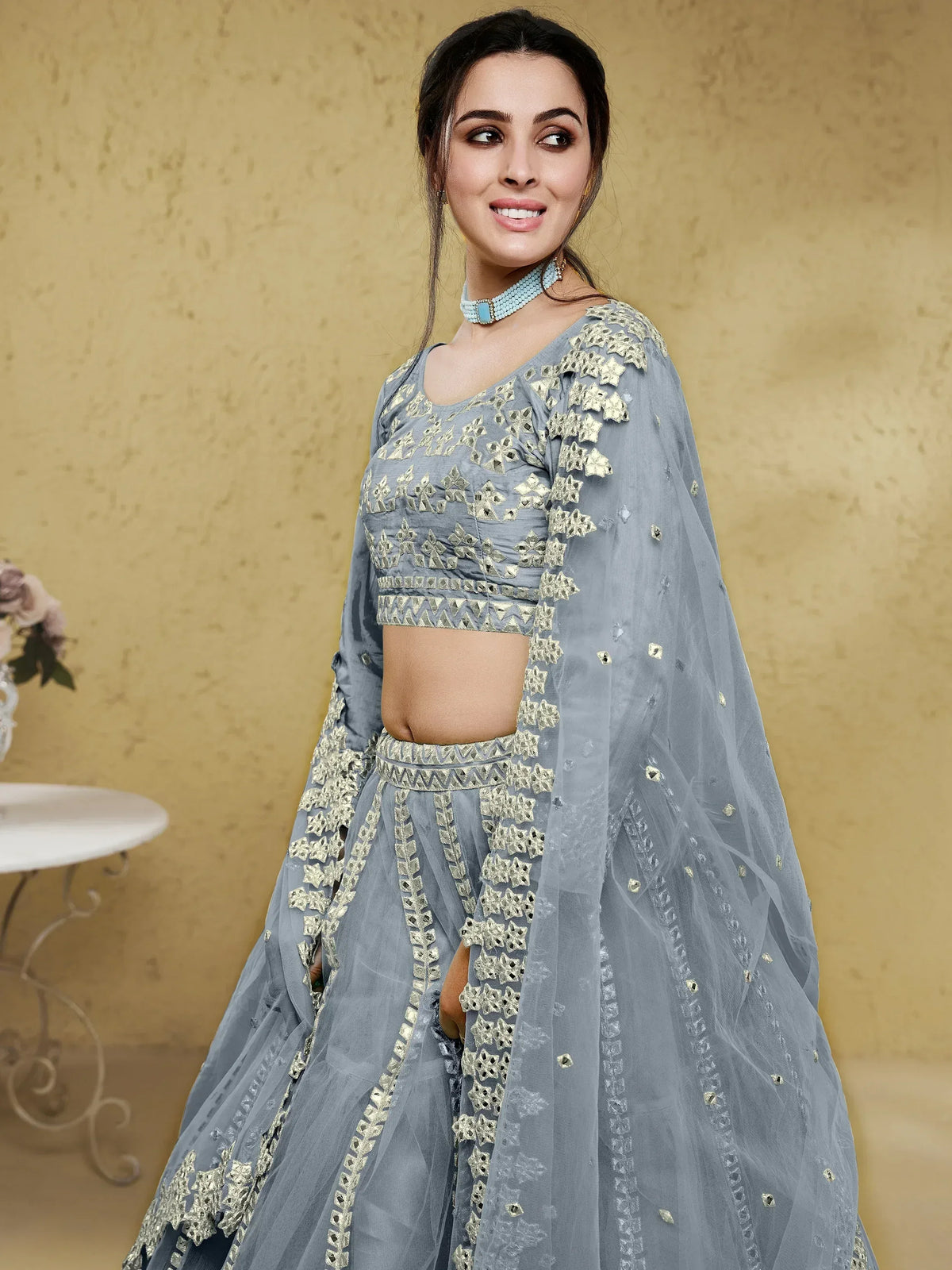 Grey designer lehenga choli with gold embroidery and mirror work, perfect for Indian ethnic wear occasions.