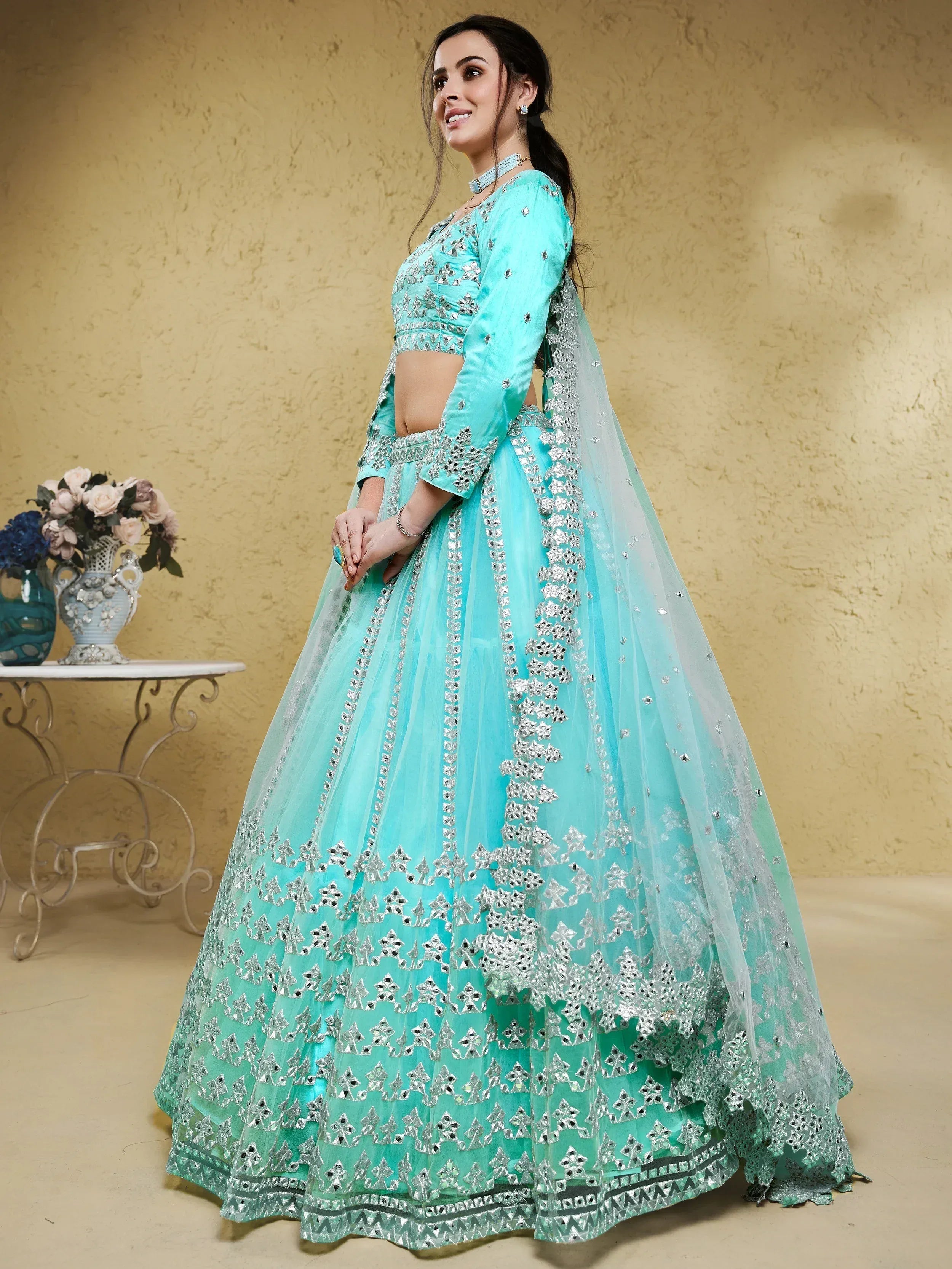 Turquoise designer lehenga choli with mirror work and net dupatta, perfect for Indian ethnic occasions